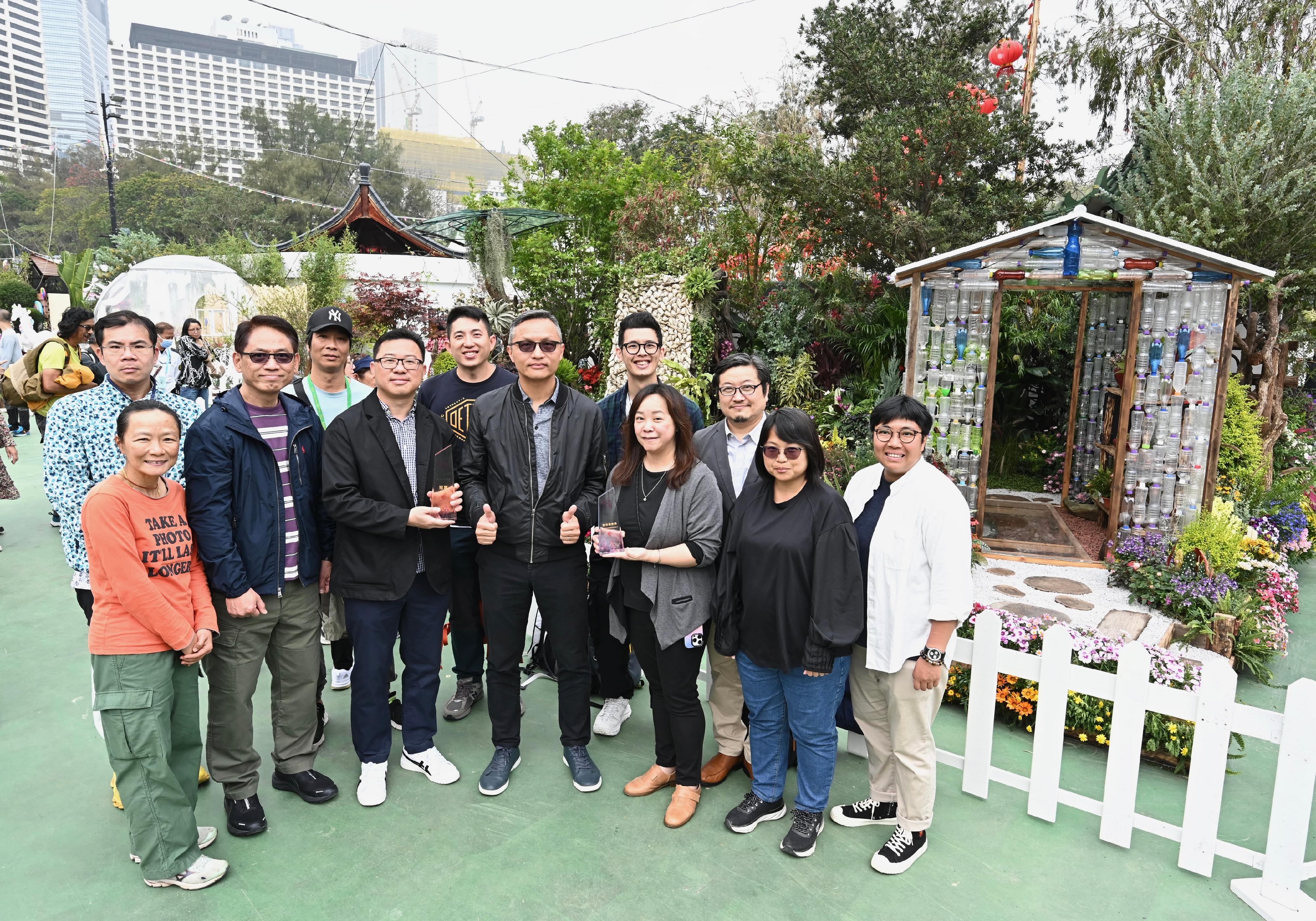 二○二四年香港花卉展覽現於維多利亞公園舉行，除了色彩繽紛的園林造景和造型優美的花藝擺設外，場內亦展出康樂及文化事務署（康文署）東方園圃及西方園圃比賽的得獎作品。圖示康文署灣仔區康樂事務辦事處員工在其得獎的西方園圃「循環生機」前合照。