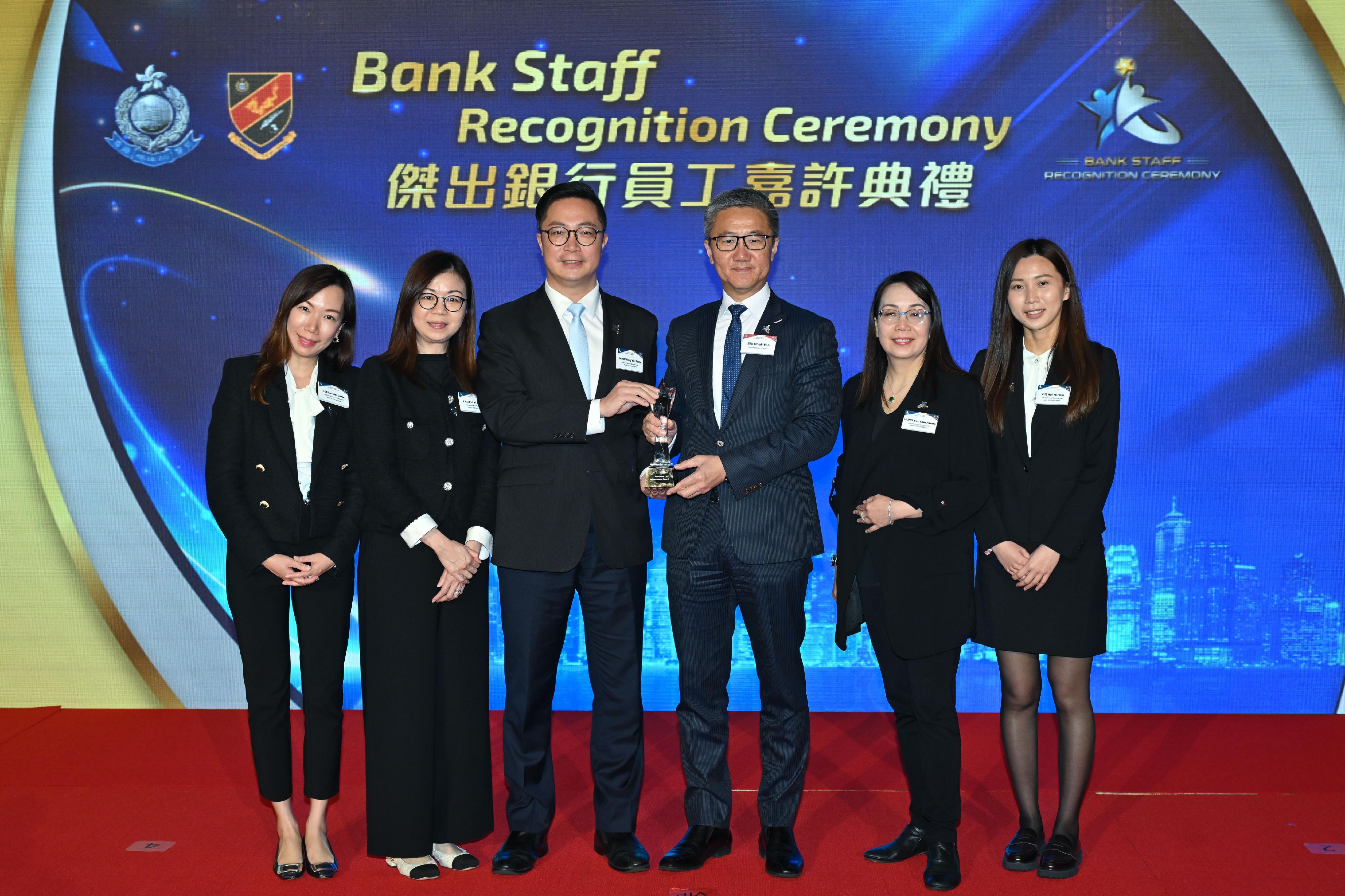 香港警务处今日（三月二十二日）举办「杰出银行员工嘉许典礼」。图示警务处处长萧泽颐（右三）颁奖予获得「防骗表现飞跃奬」的银行代表。
