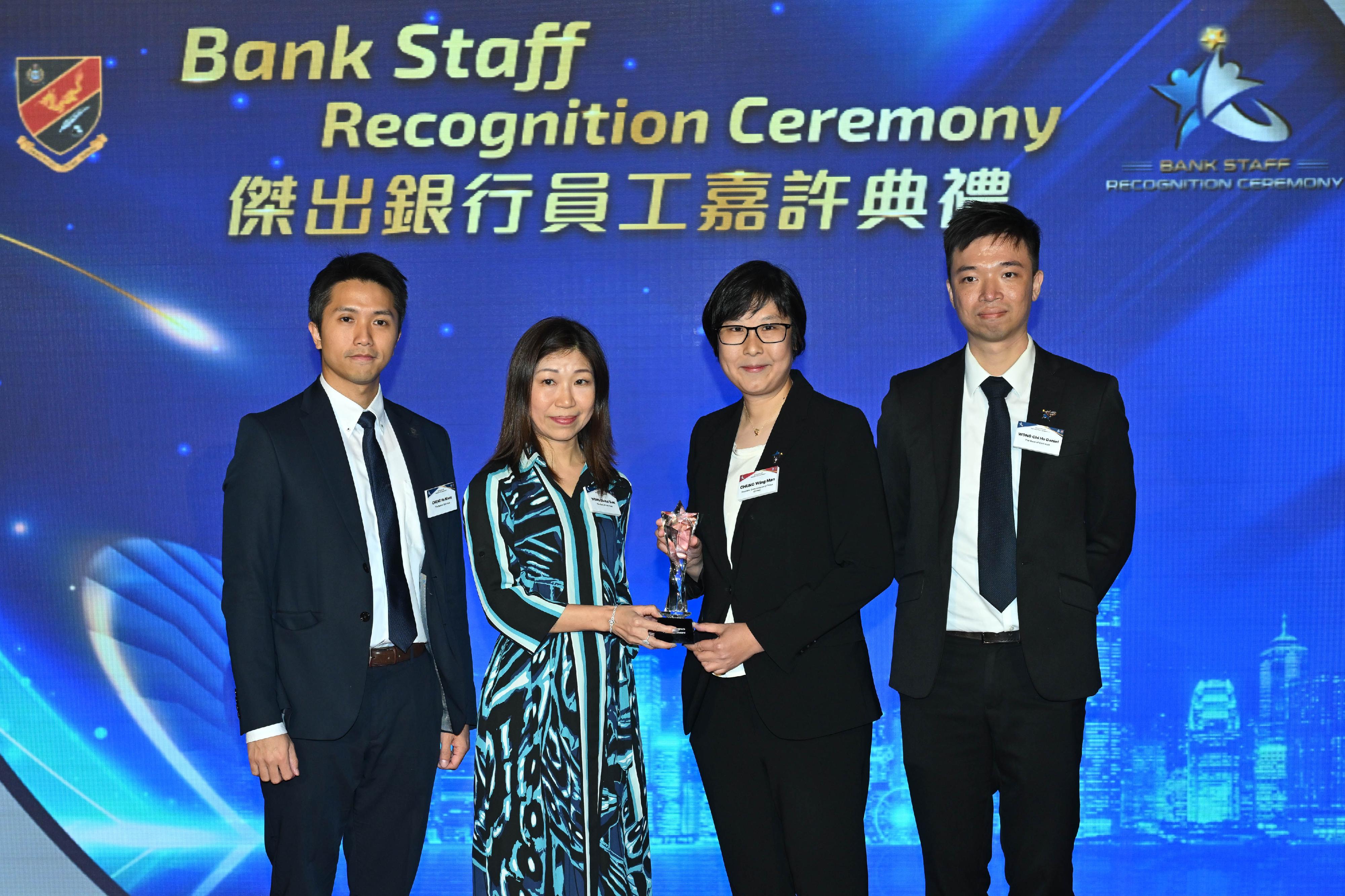 香港警务处今日（三月二十二日）举办「杰出银行员工嘉许典礼」。图示警务处助理处长（刑事）钟咏敏（右二）颁奖予获得「合规科技应用大奬」的银行代表。