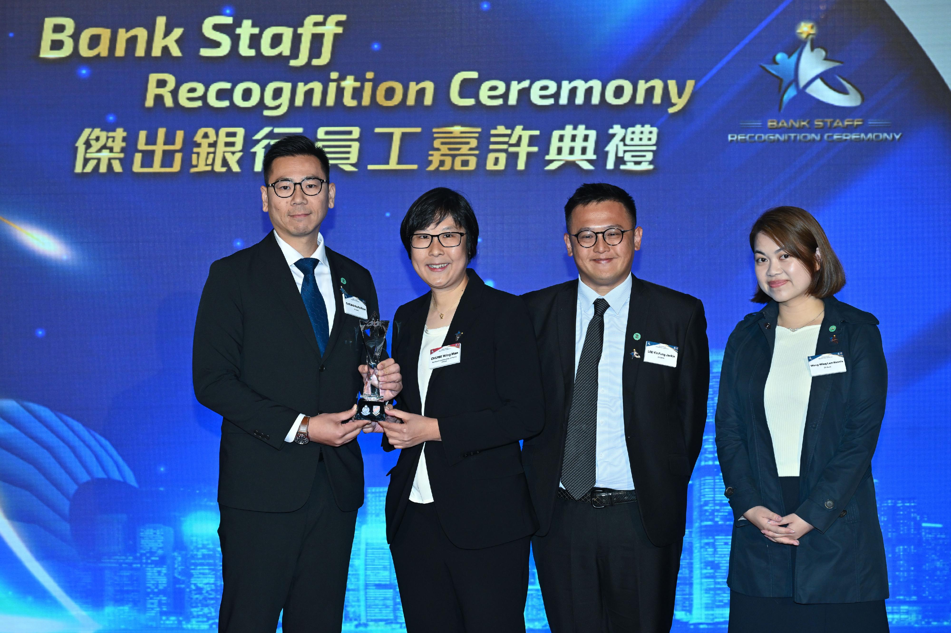 香港警務處今日（三月二十二日）舉辦「傑出銀行員工嘉許典禮」。圖示警務處助理處長（刑事）鍾詠敏（左二）頒獎予獲得「合規科技應用大奬」的銀行代表。
