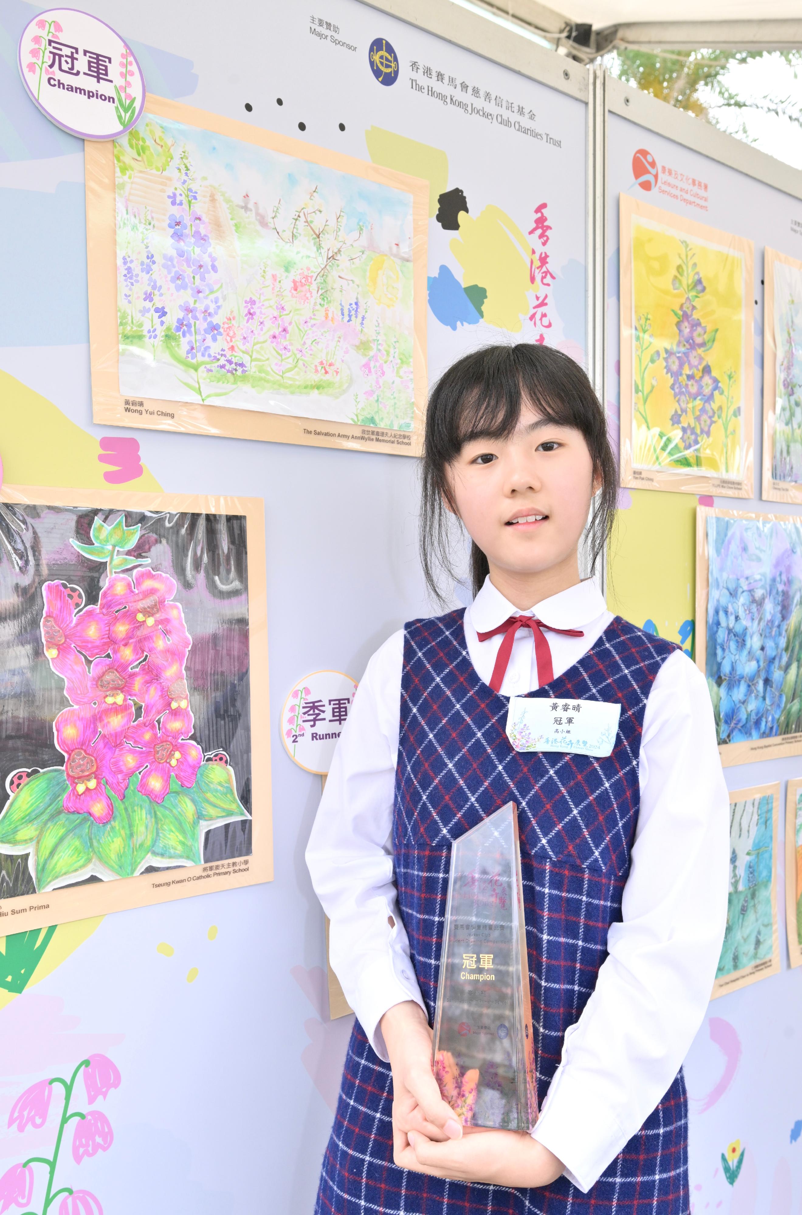 The Hong Kong Flower Show at Victoria Park will close at 9pm tomorrow (March 24). During the show period, various recreational fringe activities have been held, among which the Jockey Club Student Drawing Competition held its prize presentation ceremony today (March 23). Winning entries are now on display at the showground. Photo shows the champion of the Senior Section in Primary School, Wong Yui-ching, and her work.