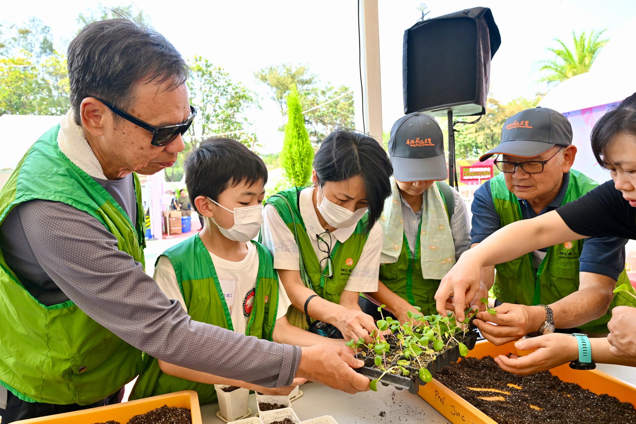 The Leisure and Cultural Services Department is once again holding Green Recycling Day (GRD) activities upon the conclusion of the Hong Kong Flower Show. The GRD activities were held today (March 25) and will continue tomorrow (March 26) at Victoria Park to reinforce green measures and reduce waste. Photo shows volunteers participating in a workshop to learn more about planting.
