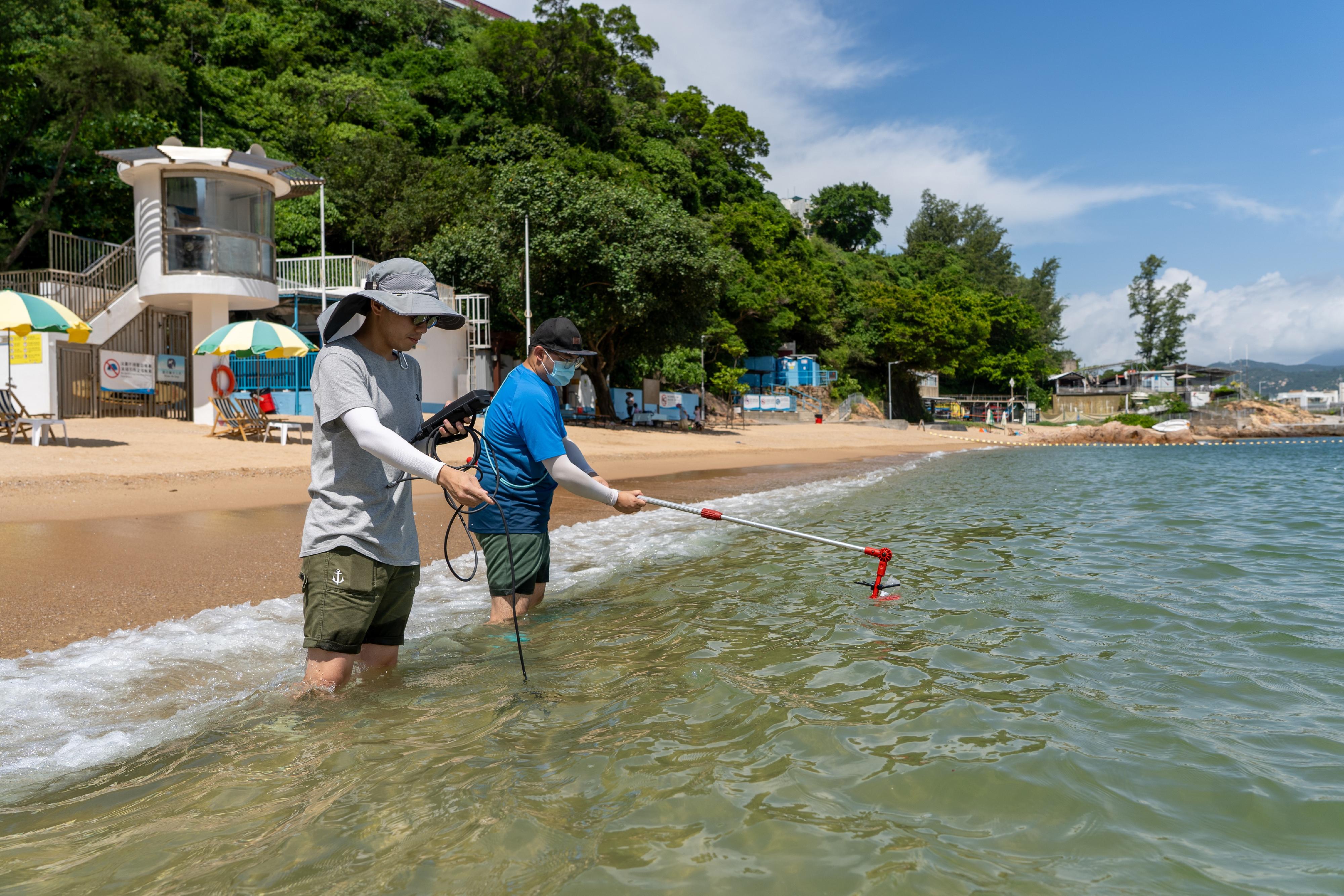 二○二三年香港泳滩水质年报显示，全港所有宪报公布泳滩已连续14年全面符合细菌水质指标。图示环境保护署人员在泳滩进行现场测量及采集海水样本。