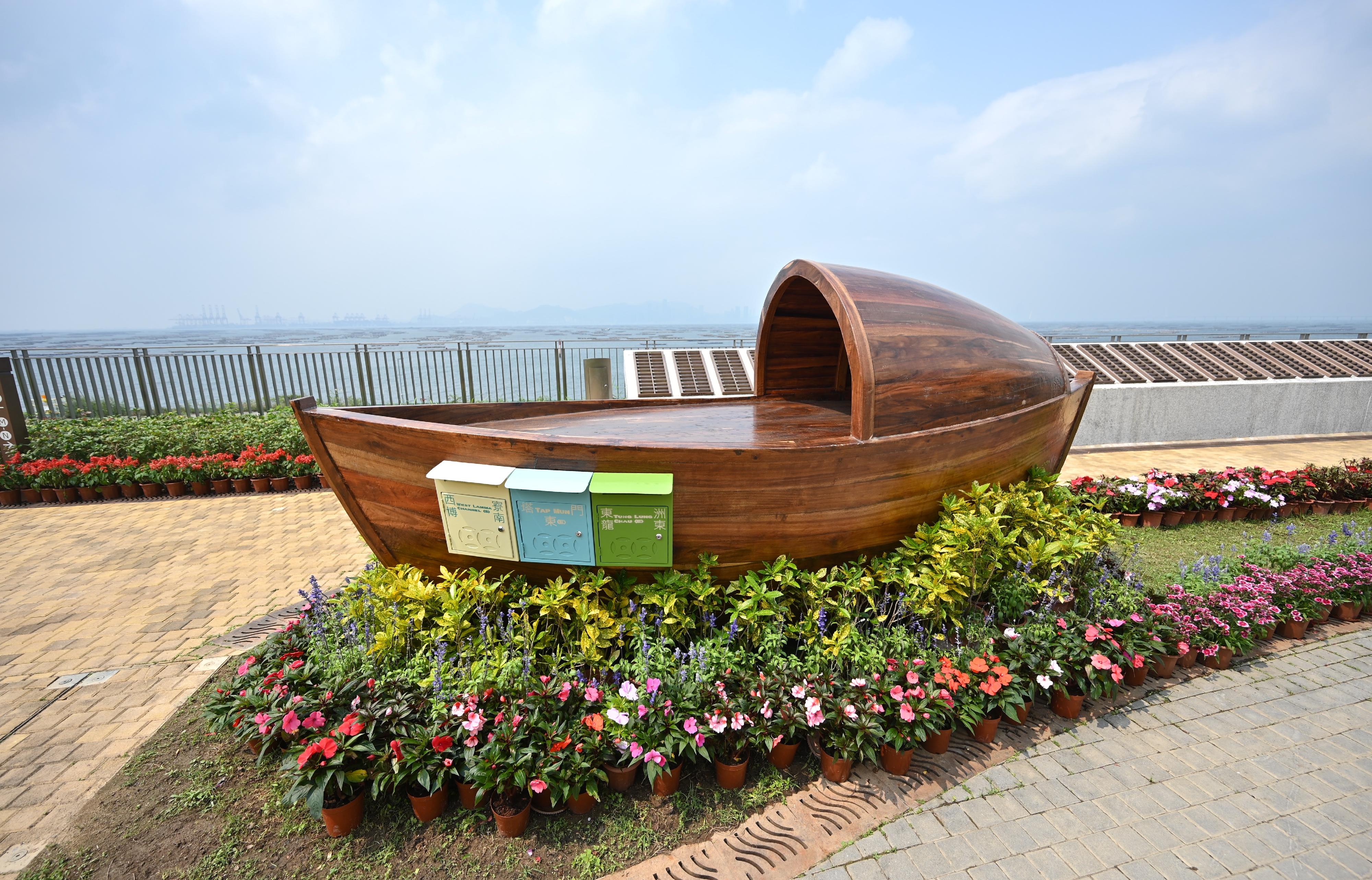 The Food and Environmental Hygiene Department said today (April 3) that to further enhance its green burial services, a wooden artwork has been installed at the Garden of Remembrance (GoR) in Tsang Tsui, Tuen Mun. Memorial post boxes with local characteristics on the artwork allow families of those who have used green burial services (including scattering of cremains at sea and in GoRs) to send their blessings and remembrance to the deceased by posting memorial notes.
