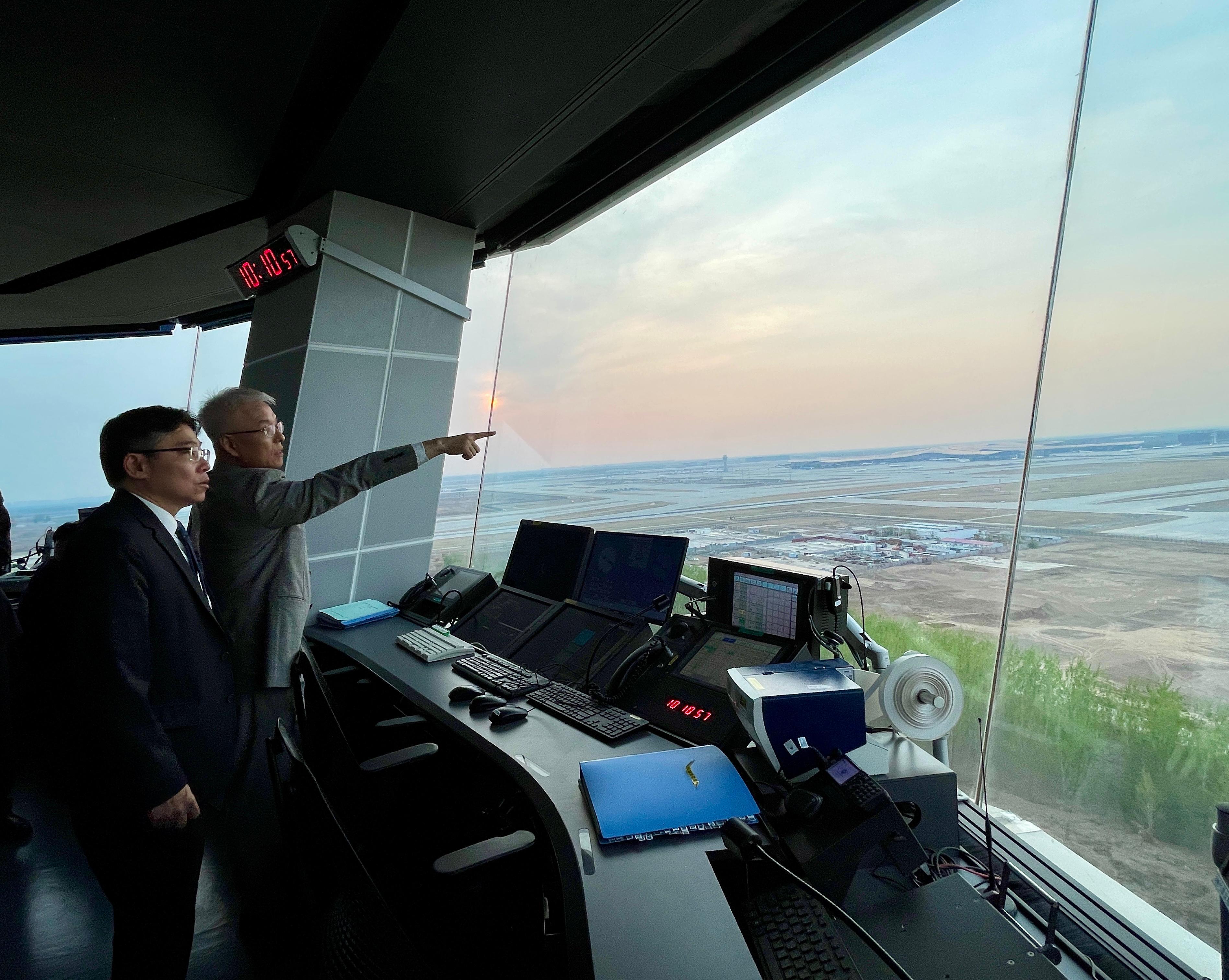 The Secretary for Transport and Logistics, Mr Lam Sai-hung, visited the control tower at Beijing Daxing International Airport yesterday (April 9). Photo shows Mr Lam (left) receiving a briefing on the operation of the air traffic control centre.