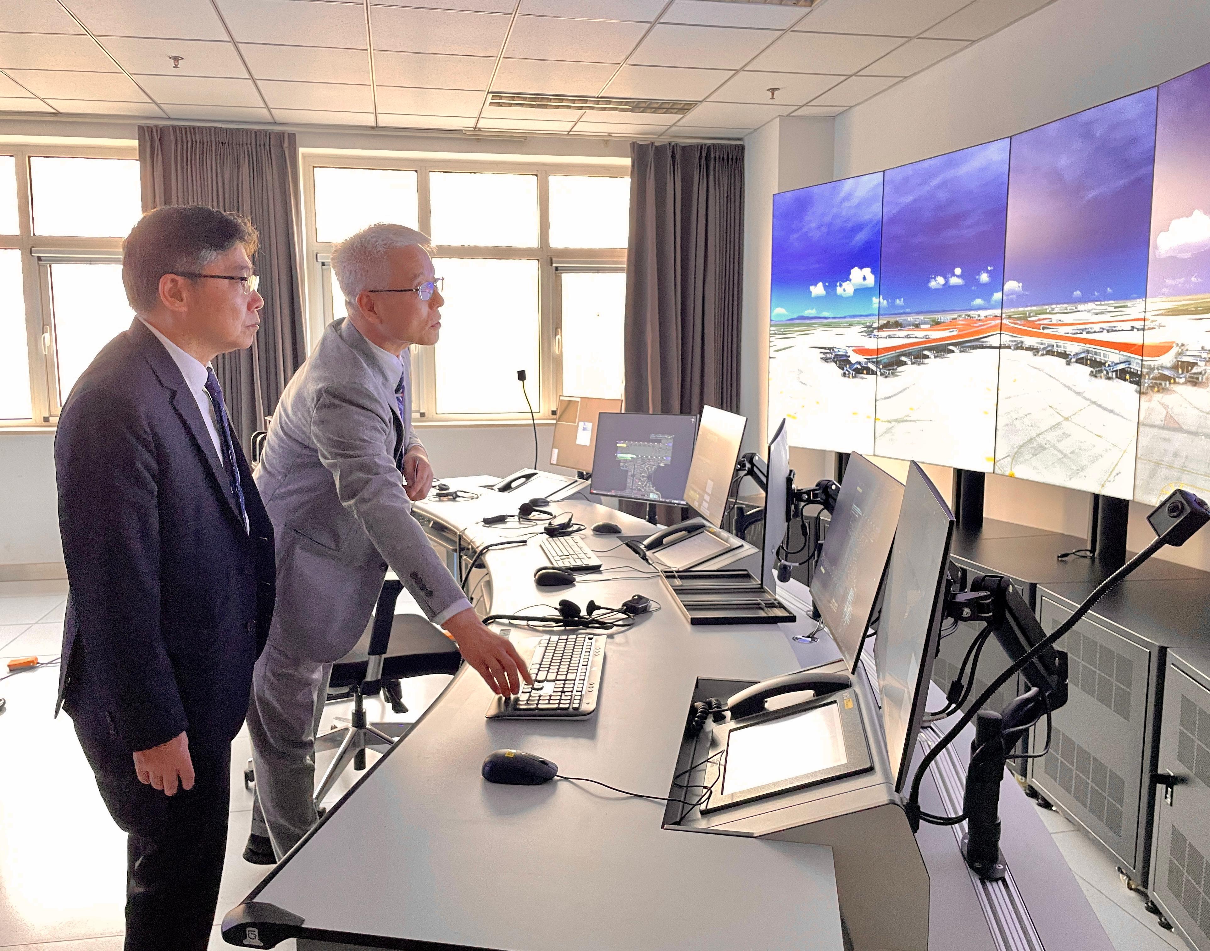 The Secretary for Transport and Logistics, Mr Lam Sai-hung, visited Beijing Daxing International Airport yesterday (April 9). Photo shows Mr Lam (left) receiving a briefing about the desktop tower control simulator.