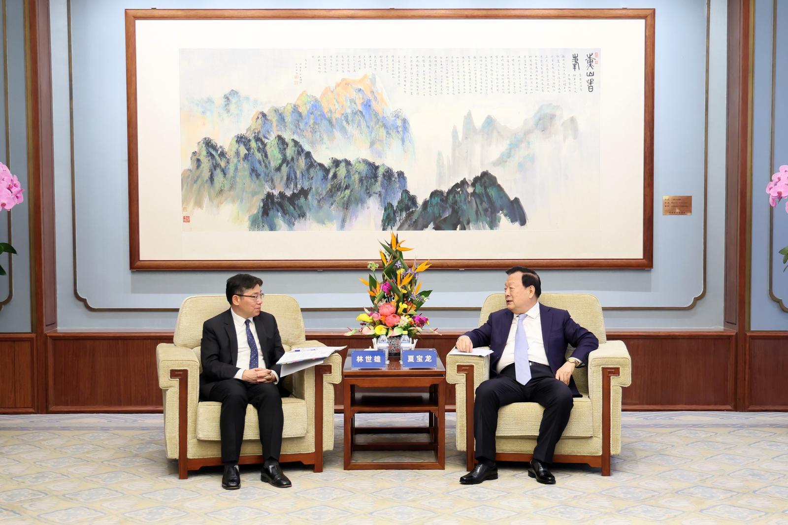 The Secretary for Transport and Logistics, Mr Lam Sai-hung (left), calls on the Director of the Hong Kong and Macao Affairs Office of the State Council, Mr Xia Baolong (right), this morning (April 10), briefing him on the latest work progress on Hong Kong's maritime, aviation and logistics developments.