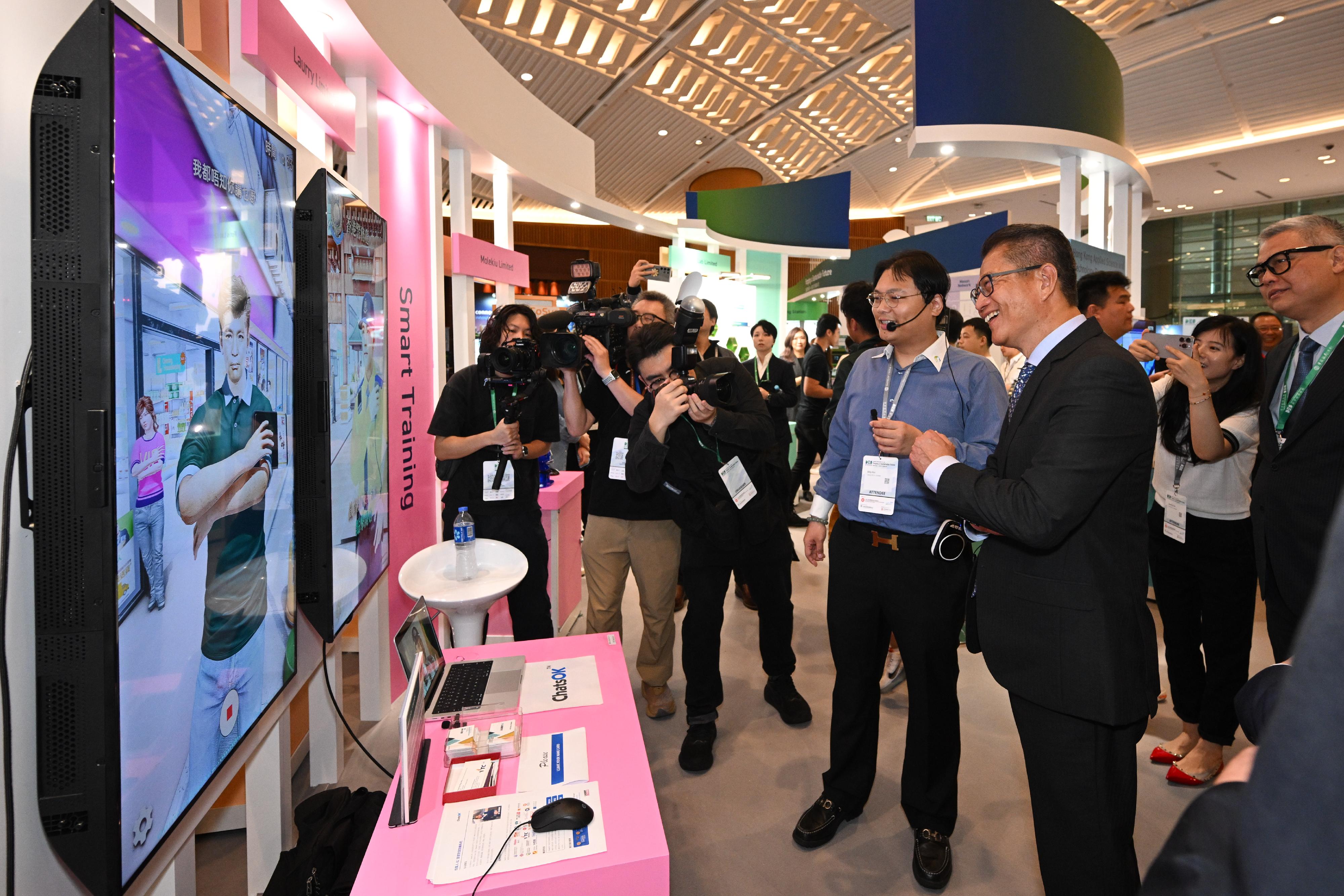 财政司司长陈茂波（前排右）今日（四月十二日）出席2024数字经济峰会透视远景论坛前参观展览。


