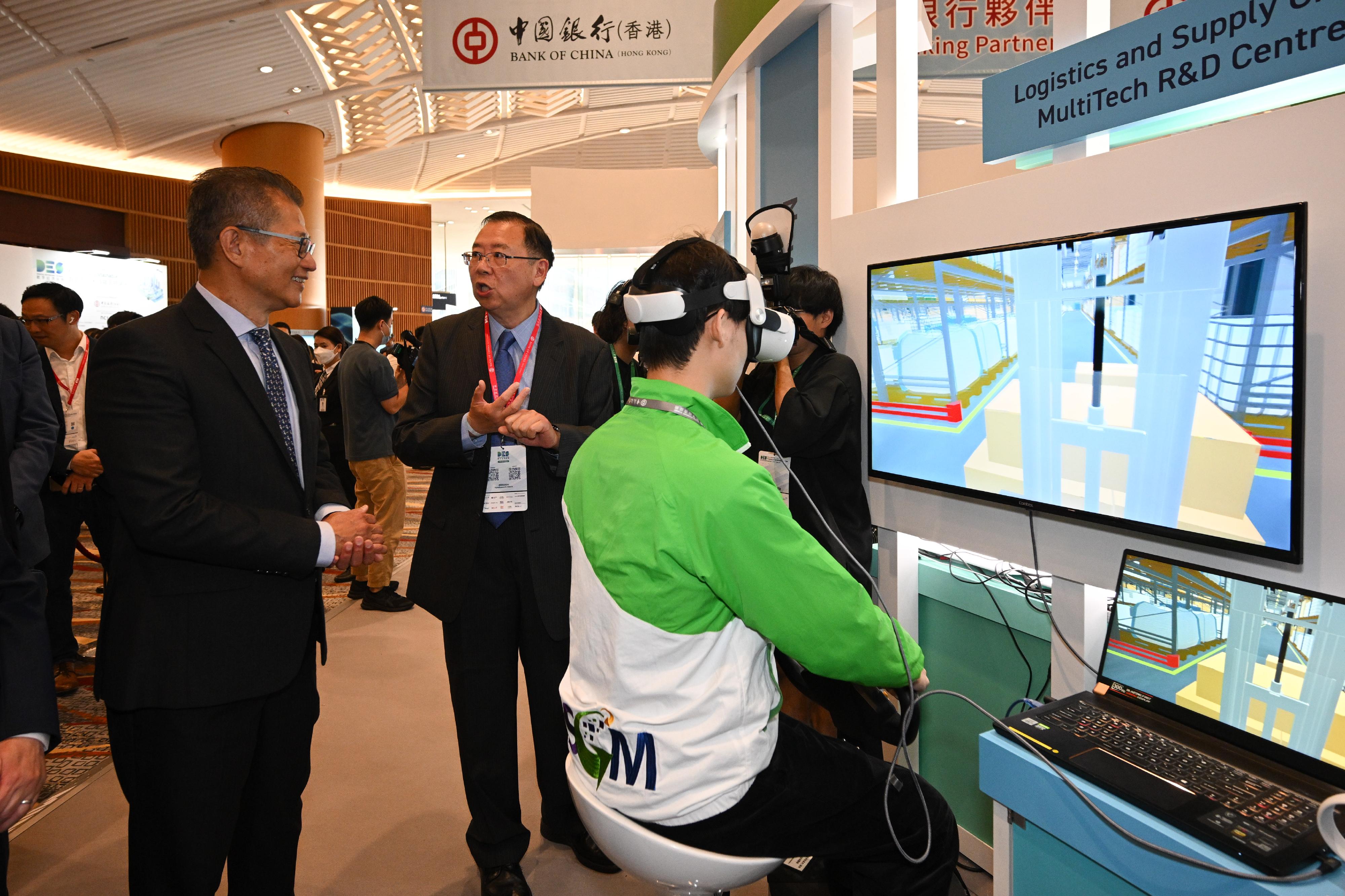 The Financial Secretary, Mr Paul Chan (first left), tours the exhibition before attending the Visionary Forum of the Digital Economy Summit 2024 today (April 12). 