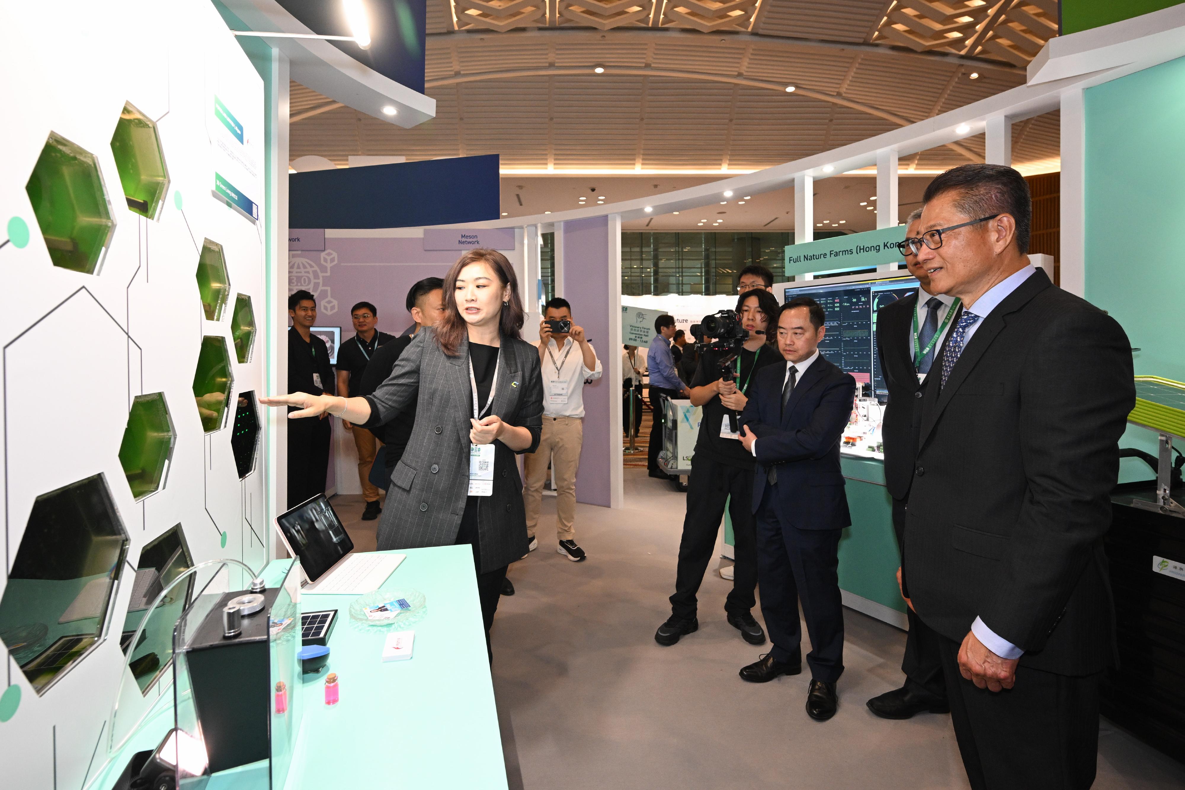 The Financial Secretary, Mr Paul Chan (first right), tours the exhibition before attending the Visionary Forum of the Digital Economy Summit 2024 today (April 12). 