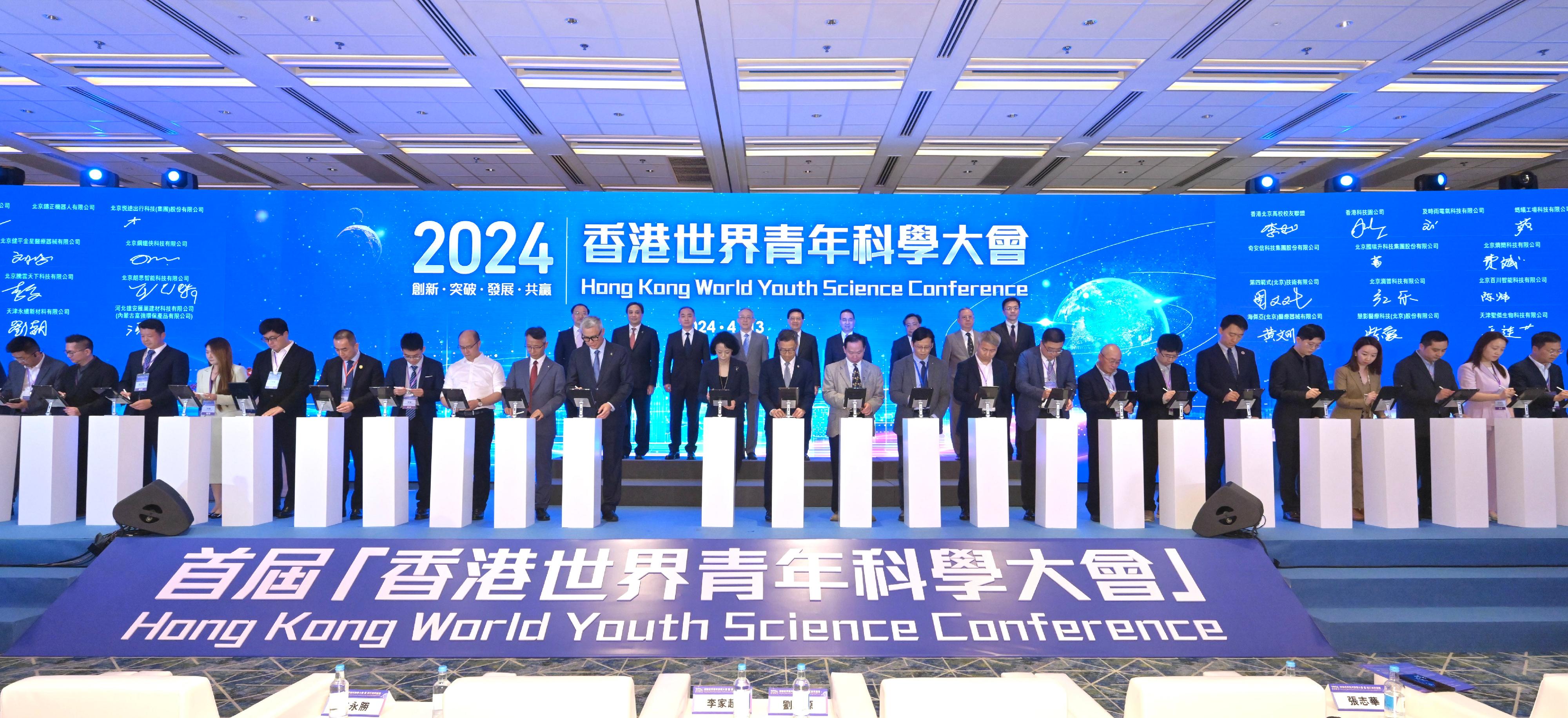 The Chief Executive, Mr John Lee, today (April 13) attended the opening ceremony of Hong Kong World Youth Science Conference and the Xiangjiang Nobel Forum 2024. Photo shows Mr Lee (back row, centre); Deputy Director of the Liaison Office of the Central People's Government in the Hong Kong Special Administrative Region (HKSAR) Mr Liu Guangyuan (back row, fourth right); Deputy Commissioner of the Office of the Commissioner of the Ministry of Foreign Affairs of the People's Republic of China in the HKSAR Mr Li Yongsheng (back row, fourth left); and other guests, witnessing the Memoranda of Understanding signing ceremony that signifies the intention of I&T (innovation and technology) enterprises from the Beijing-Tianjin-Hebei and Xiongan area to develop in Hong Kong.