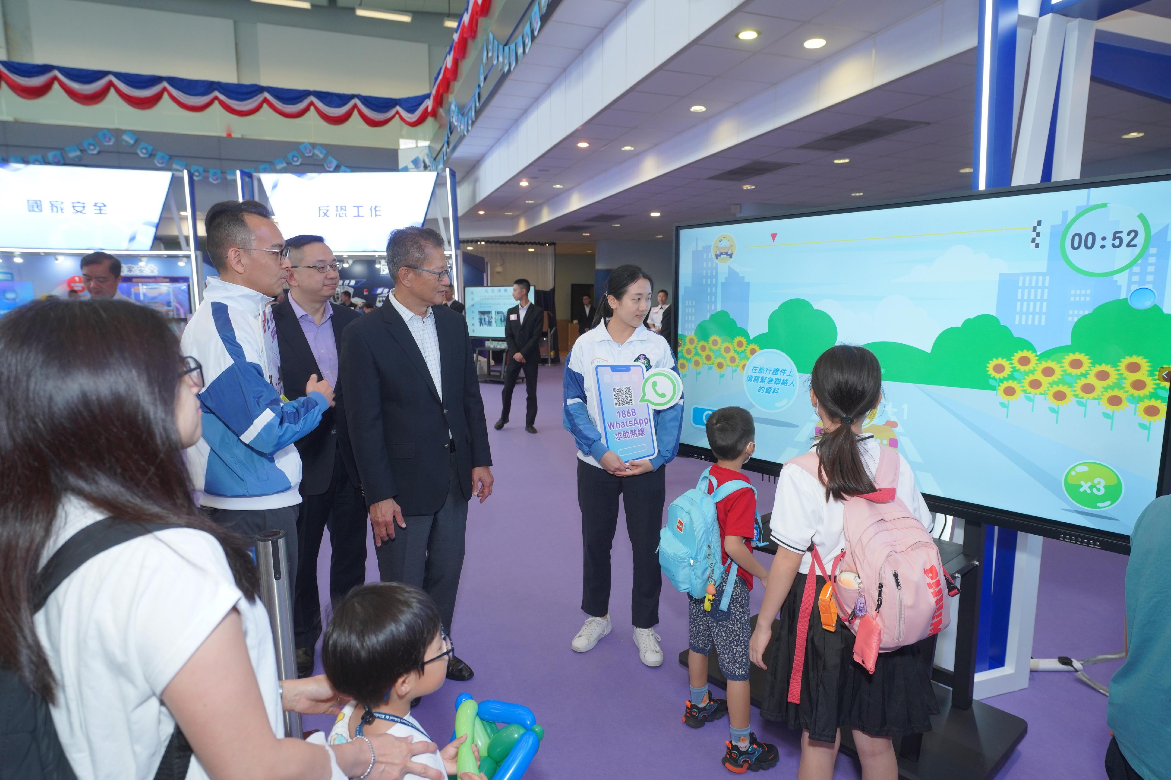 To support the National Security Education Day, the Immigration Service Institute of Training and Development held an open day today (April 13). Photo shows the Financial Secretary, Mr Paul Chan (second right), accompanied by the Director of Immigration, Mr Benson Kwok (third right), visiting an exhibition booth.