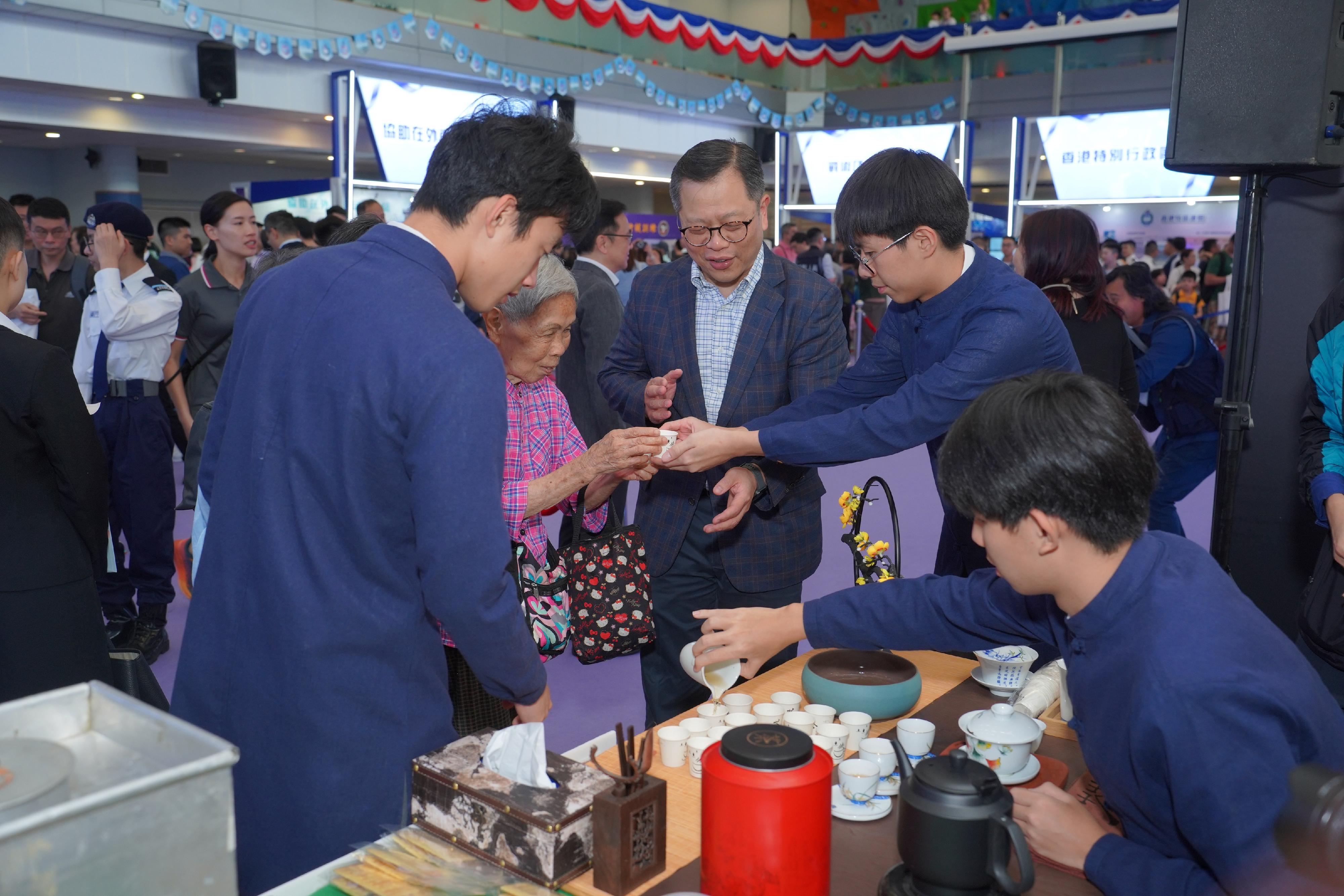 To support the National Security Education Day, the Immigration Service Institute of Training and Development held an open day today (April 13). Photo shows members of the Immigration Department Youth Leaders Corps promoting Chinese tea artistry and Hong Kong local food culture to members of the public, enriching their understanding of the major field - cultural security.