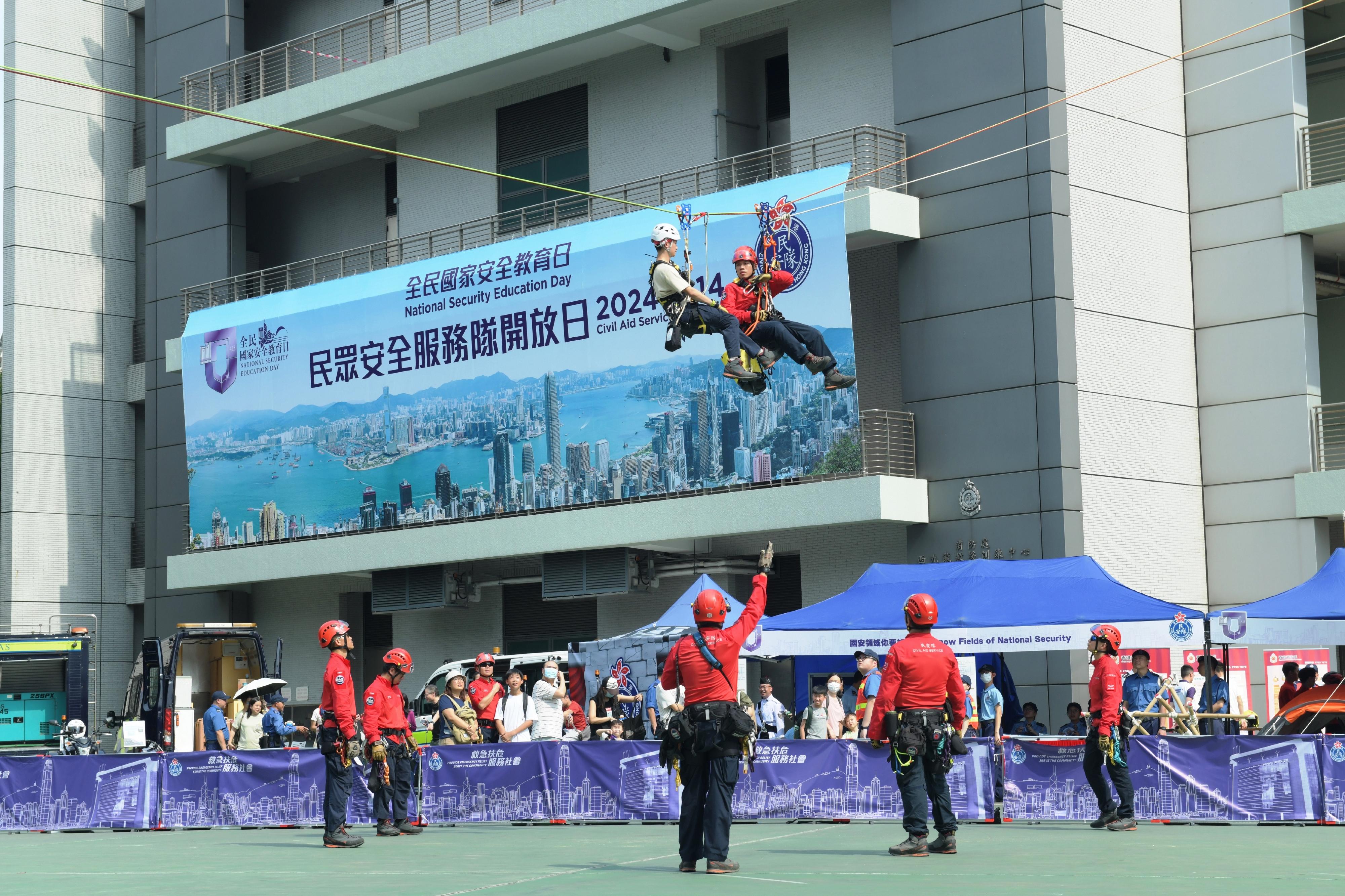 The Civil Aid Service (CAS) held an open day at its headquarters today (April 14) to promote the National Security Education Day. Photo shows CAS members performing a mountain search-and-rescue demonstration.