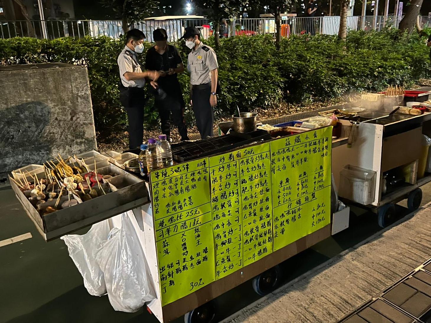 A spokesman for the Food and Environmental Hygiene Department (FEHD) said today (April 18) that to enhance evidence collection efficiency and minimise safety risks to passers-by and law enforcement officers, the FEHD conducted a pilot enforcement operation codenamed "Nighthawk" against suspected organised unlicensed cooked food hawking activities in the area of Choi Yuen Road near Po Shek Wu Estate Ancillary Facilities Block in Sheung Shui last night (April 17). Officers used video recording devices to document illegal acts and gather information on unlicensed cooked food hawkers there as evidence.