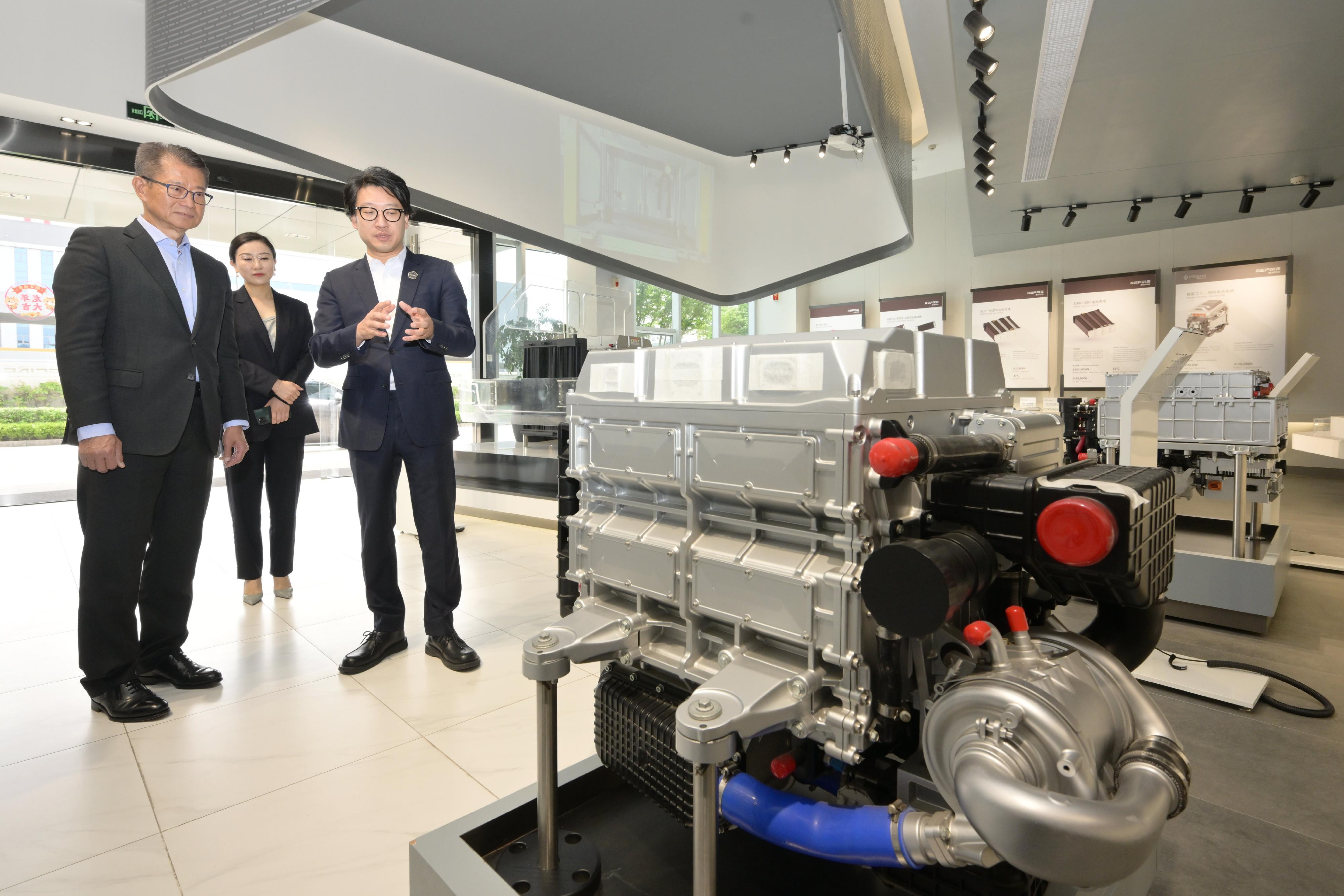 陳茂波（左一）早上前往一家從事氫能動力研發的企業，並參觀其燃料電池系統。