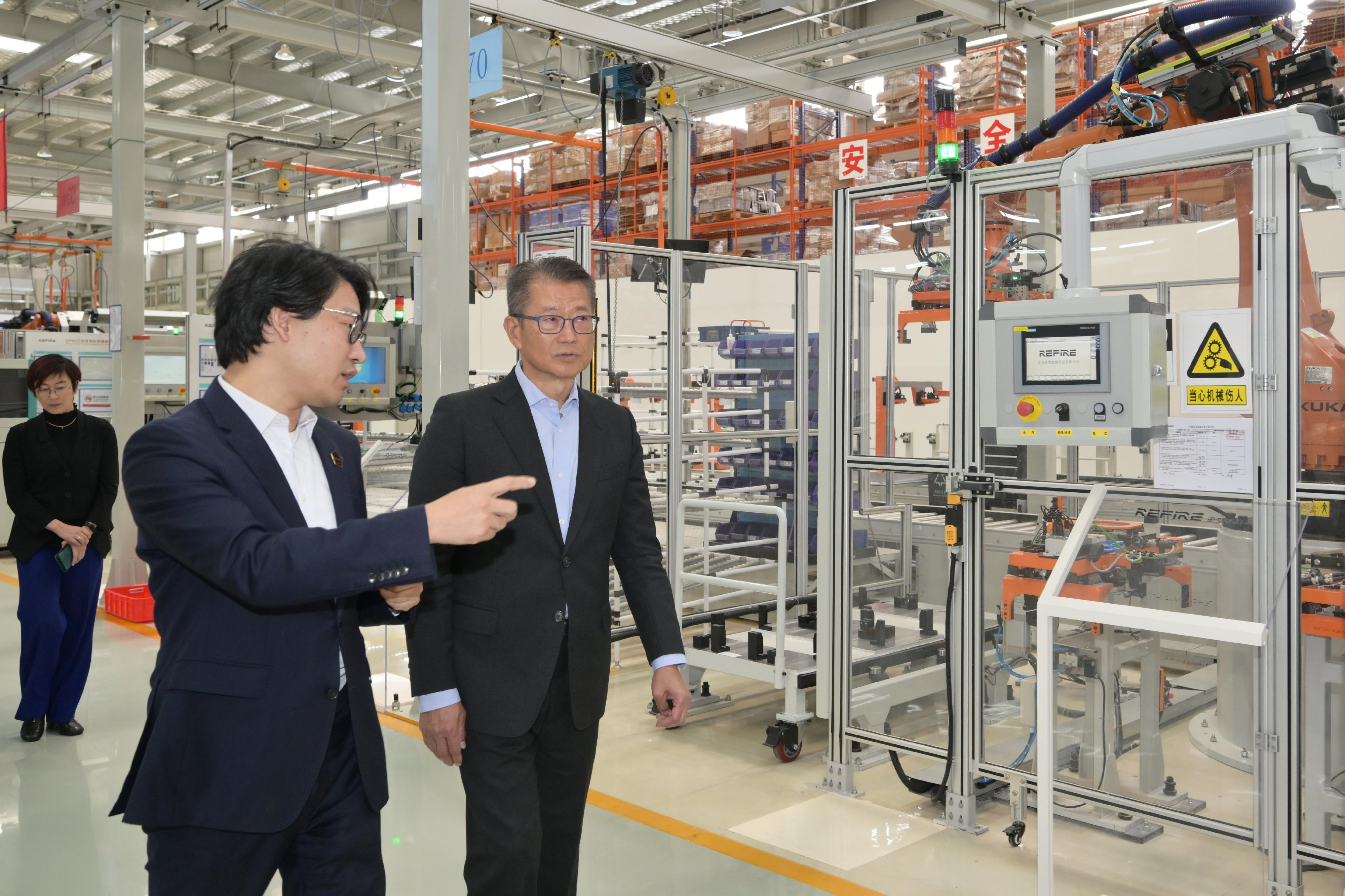 陳茂波（右一）早上前往一家從事氫能動力研發的企業，並參觀其廠房。