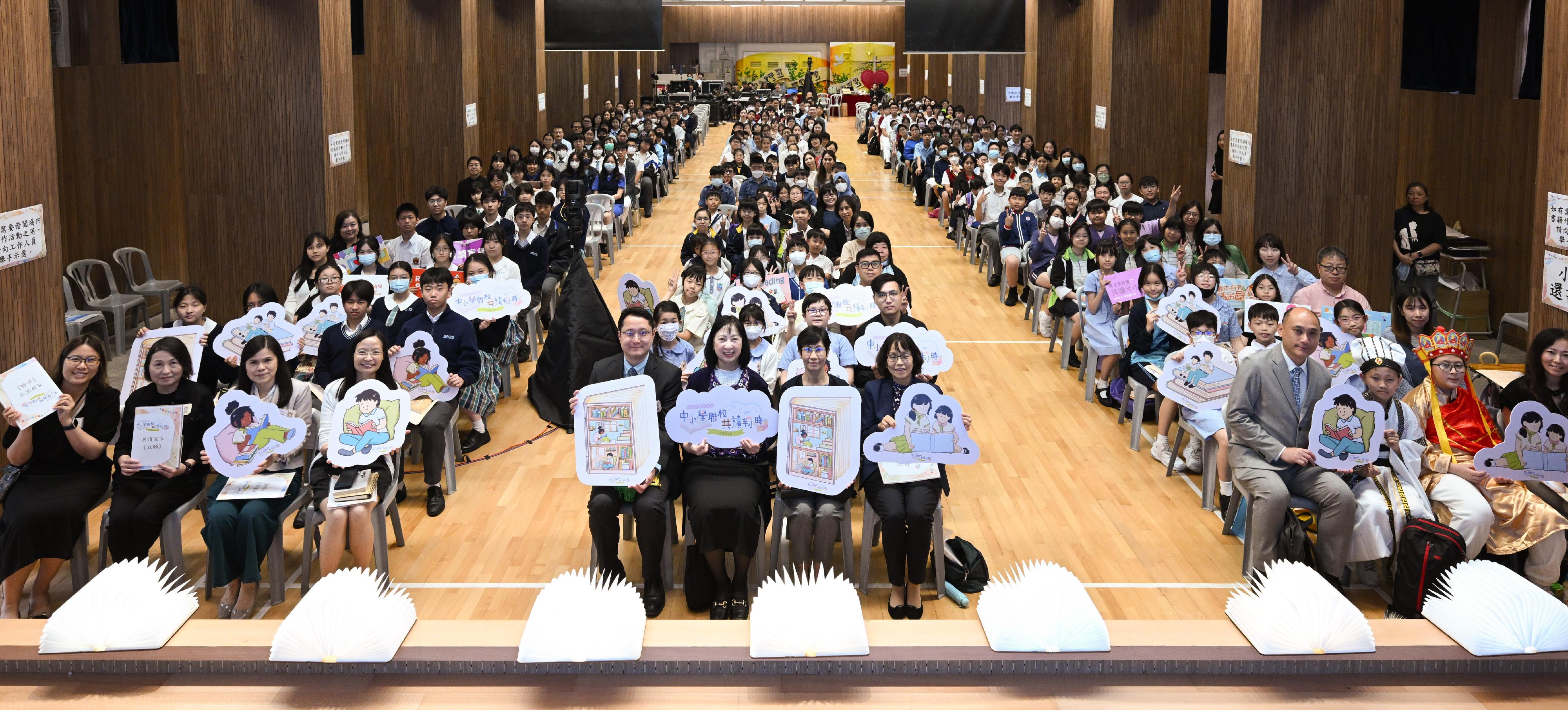 The Education Bureau held joint secondary and primary school 30-minute reading activities, on the first Hong Kong Reading for All Day today (April 23) with more than 220 schools participating. Photo shows the Permanent Secretary for Education, Ms Michelle Li (second left, front row); the Chief Librarian of Hong Kong Public Libraries Ms Carmen Tse (second right, front row); and the Principal of the HKSKH Bishop Hall Secondary School, Mr Kam Wai-ming (first left, front row), attending the opening ceremony at the school with other guests.