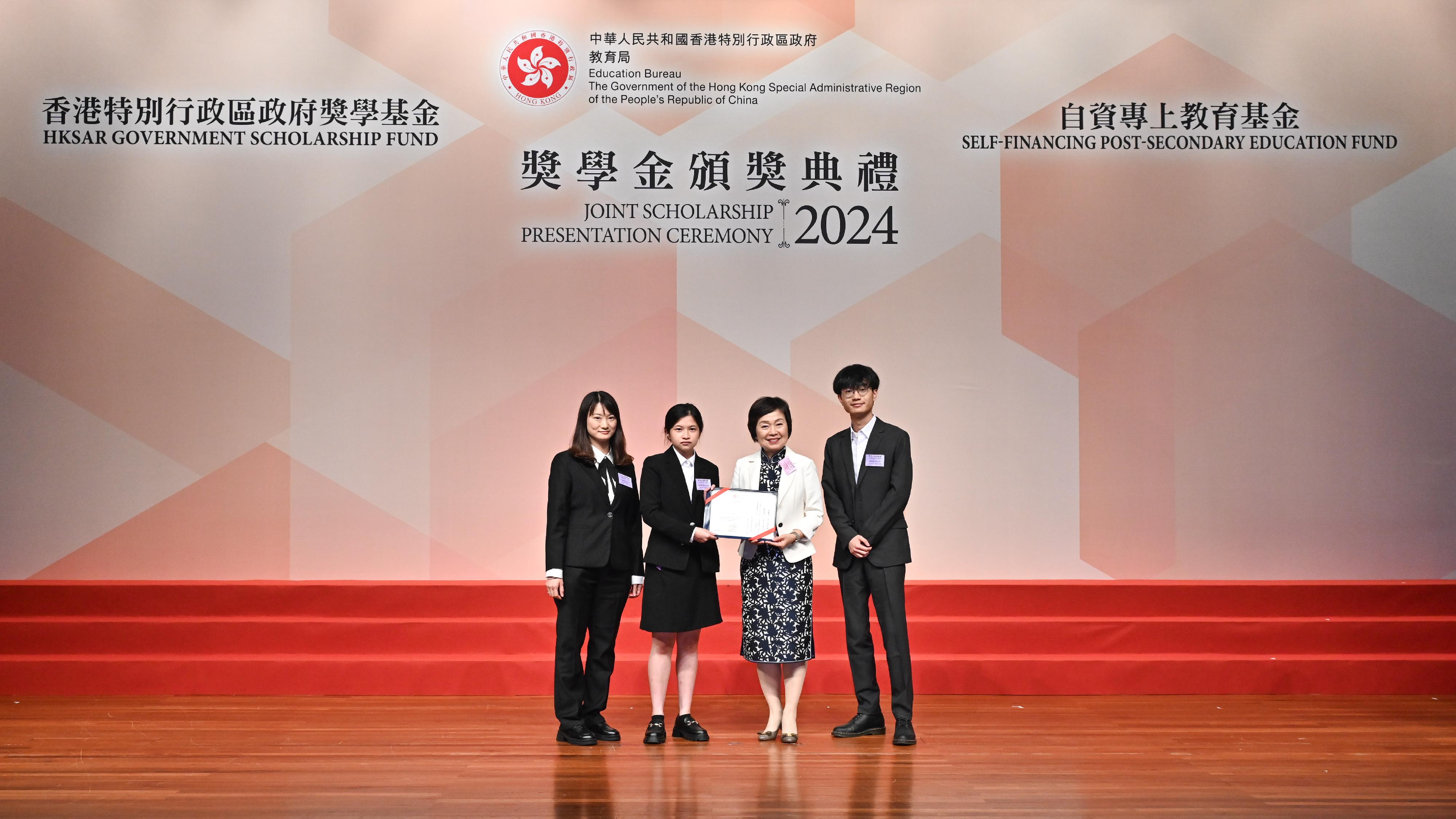 The Education Bureau held the HKSAR Government Scholarship Fund and Self-financing Post-secondary Education Fund Joint Scholarship Presentation Ceremony today (April 25). Photo shows the Secretary for Education, Dr Choi Yuk-lin (second right), presenting a certificate to students who are awarded scholarships under the Self-financing Post-secondary Education Fund.