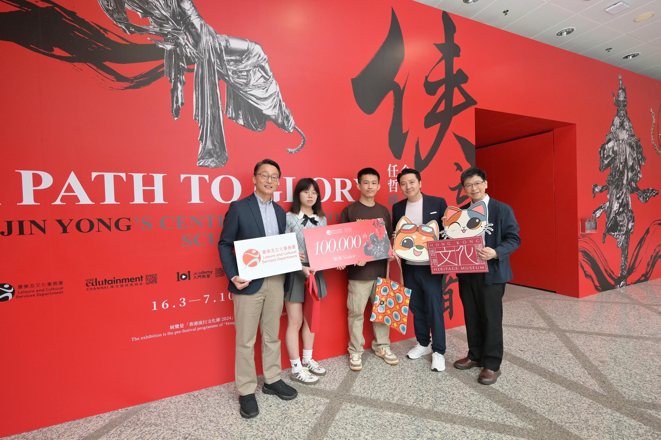 香港文化博物館的「俠之大者──金庸百年誕辰紀念．任哲雕塑展」自三月十六日開展以來，已有十萬人次前來參觀。圖示康樂及文化事務署署長劉明光（左一）、聯合策展人方圓明（右二）及香港文化博物館署理總館長鄧民亮博士（右一），今日（五月一日）在博物館歡迎展覽第10萬名訪客並送上紀念品。