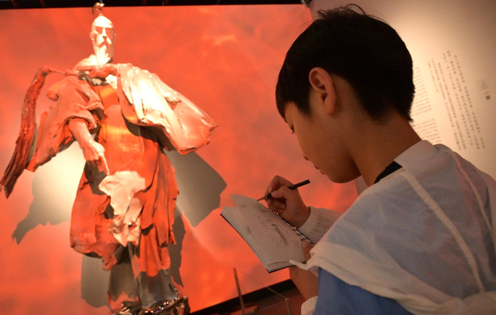 The "A Path to Glory - Jin Yong's Centennial Memorial, Sculpted by Ren Zhe" exhibition at the Hong Kong Heritage Museum has reached 100 000 visitors since its opening on March 16. Photo shows a visitor touring the exhibition.