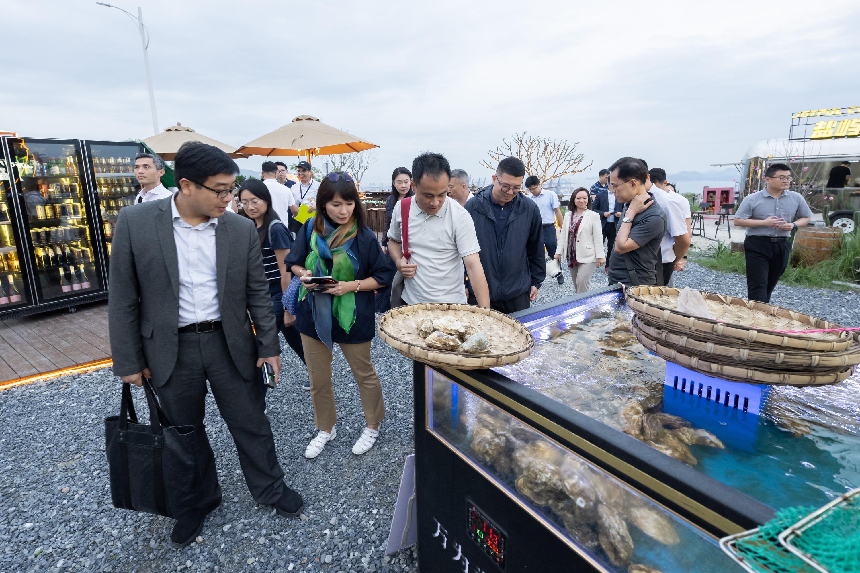 The Legislative Council Subcommittee on Matters Relating to the Development of the Northern Metropolis visits Shenzhen to examine development of eco-tourism today (May 9). Photo shows Members learning about the experience in hosting cross-border food festivals at Yantian Harbour Night Market.
