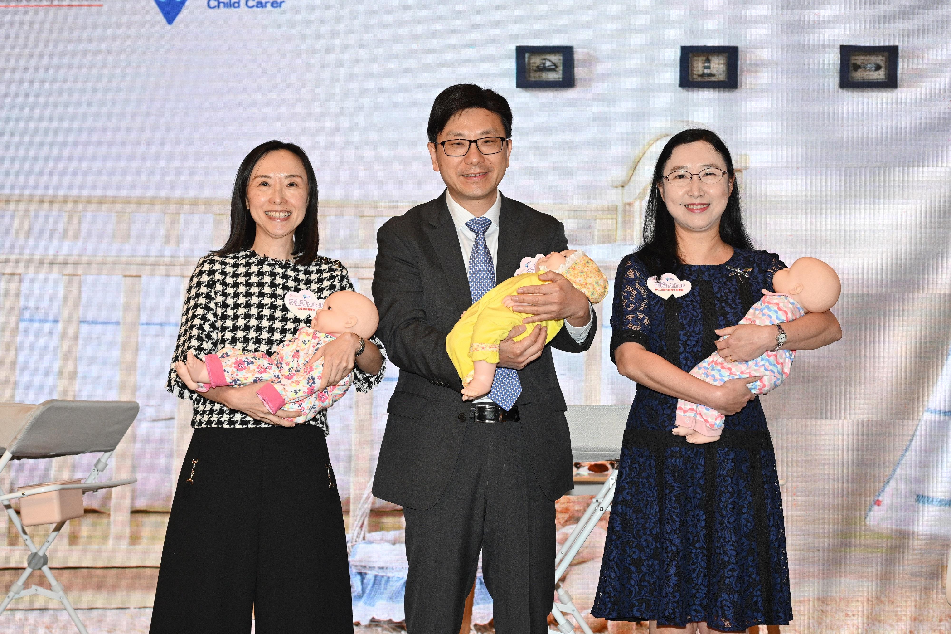 The Social Welfare Department (SWD) today (May 10) held a commendation ceremony for the Neighbourhood Support Child Care Project. Photo shows the Secretary for Labour and Welfare, Mr Chris Sun (centre); the Permanent Secretary for Labour and Welfare, Ms Alice Lau (right); and the Director of Social Welfare, Miss Charmaine Lee (left), in a simulated babysitting training for home-based child carers with the assistance of child care workers.