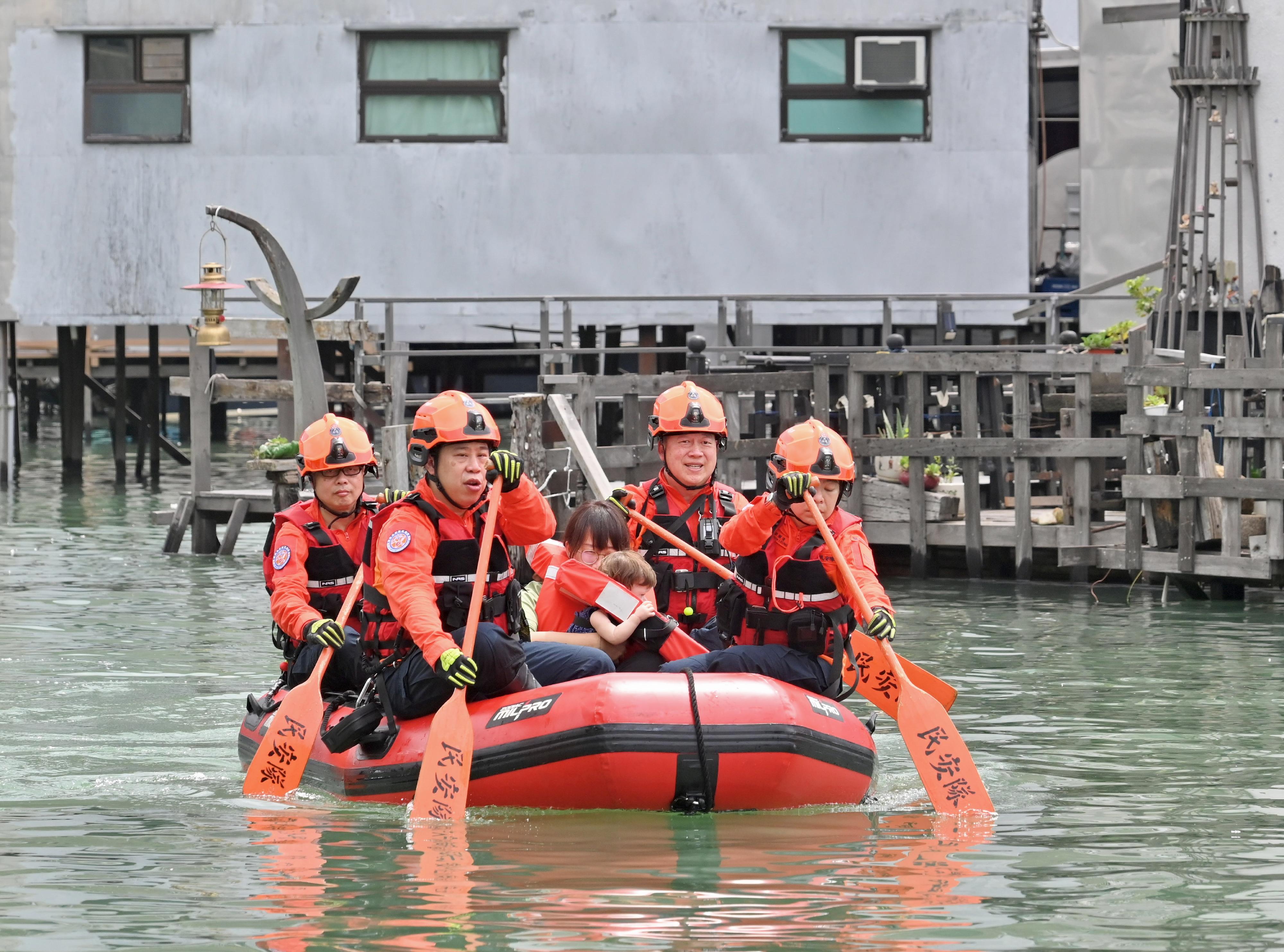 The Islands District Office (IsDO) conducted an inter-departmental rescue and evacuation drill to enhance the IsDO's, relevant government departments', local organisations' and residents' preparedness in the event of flooding in Tai O today (May 10). Photo shows Civil Aid Service members rescuing a trapped resident by an inflatable boat during the drill.