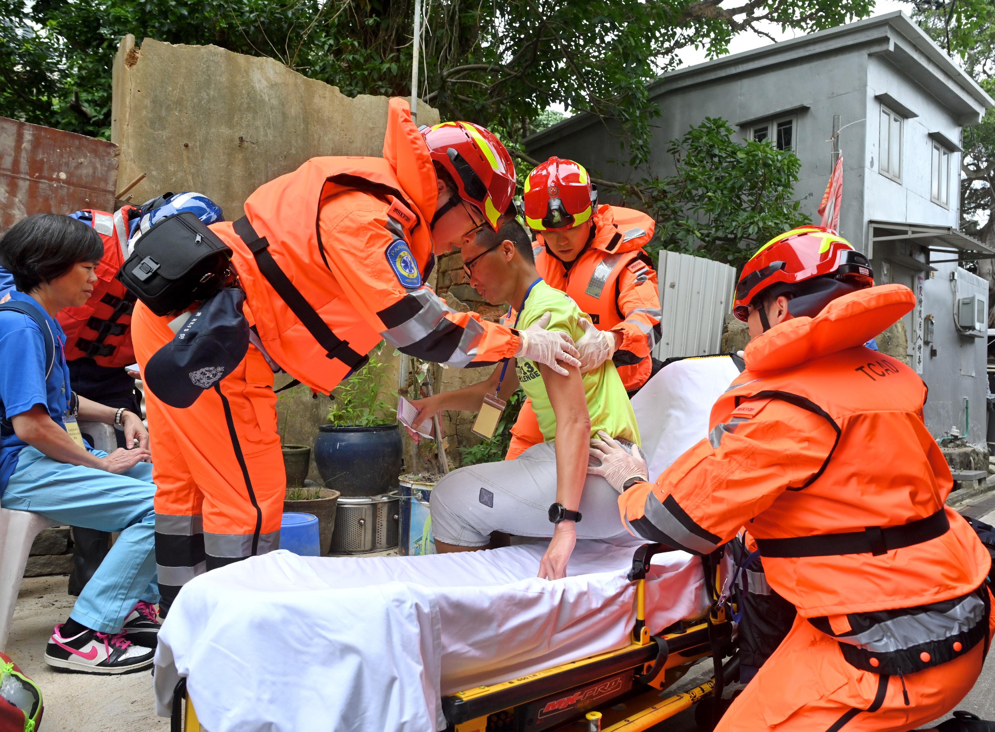 The Islands District Office (IsDO) conducted an inter-departmental rescue and evacuation drill to enhance the IsDO's, relevant government departments', local organisations' and residents' preparedness in the event of flooding in Tai O today (May 10). Photo shows officers from the Fire Services Department and Civil Aid Service rescuing a resident who has called for assistance during the drill.