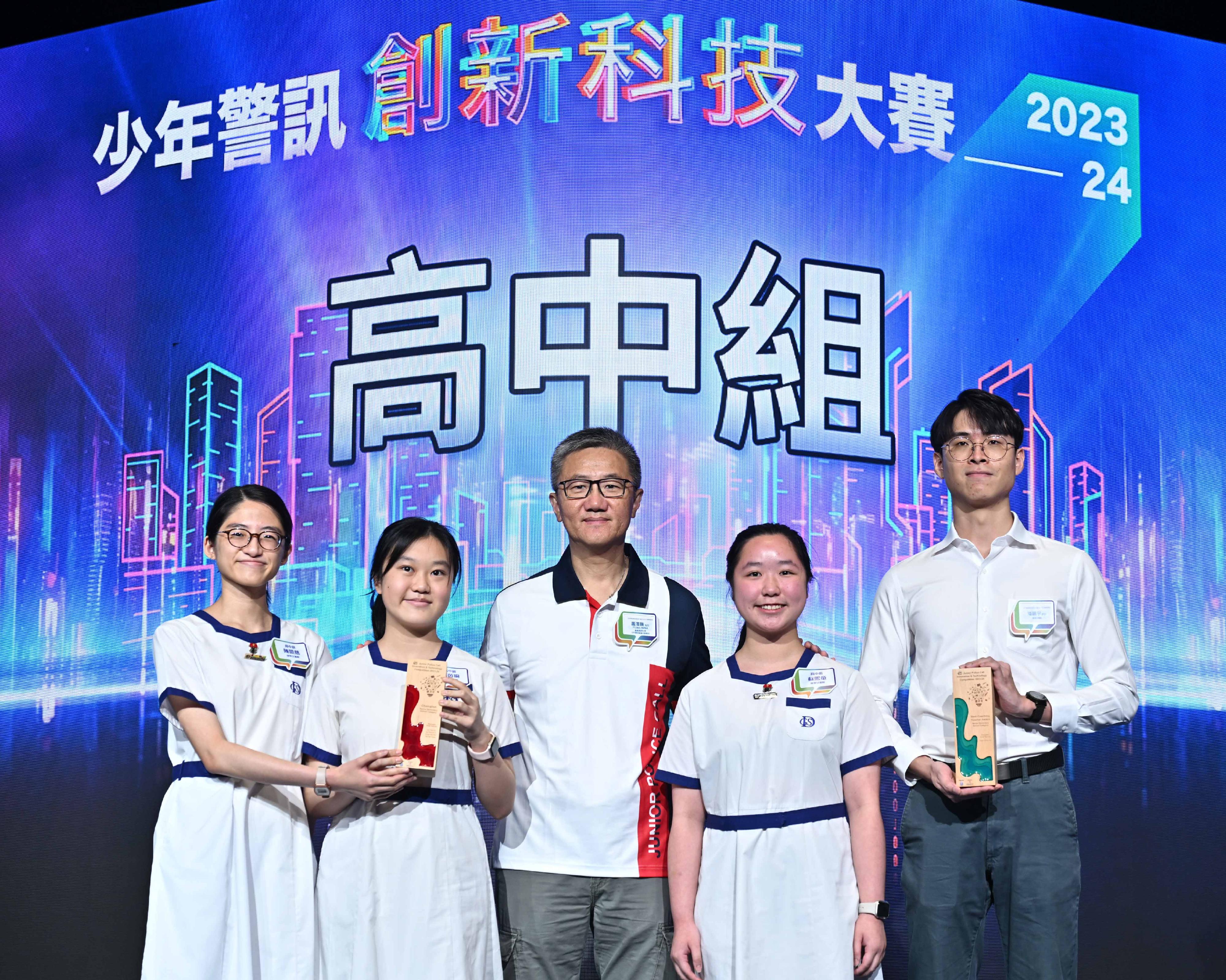 少年警讯主办的「少年警讯创新科技大赛 2023-24」今日（五月十一日）在香港会议展览中心举行颁奖典礼。图示警务处处长萧泽颐（中）颁发高中组冠军奬项。