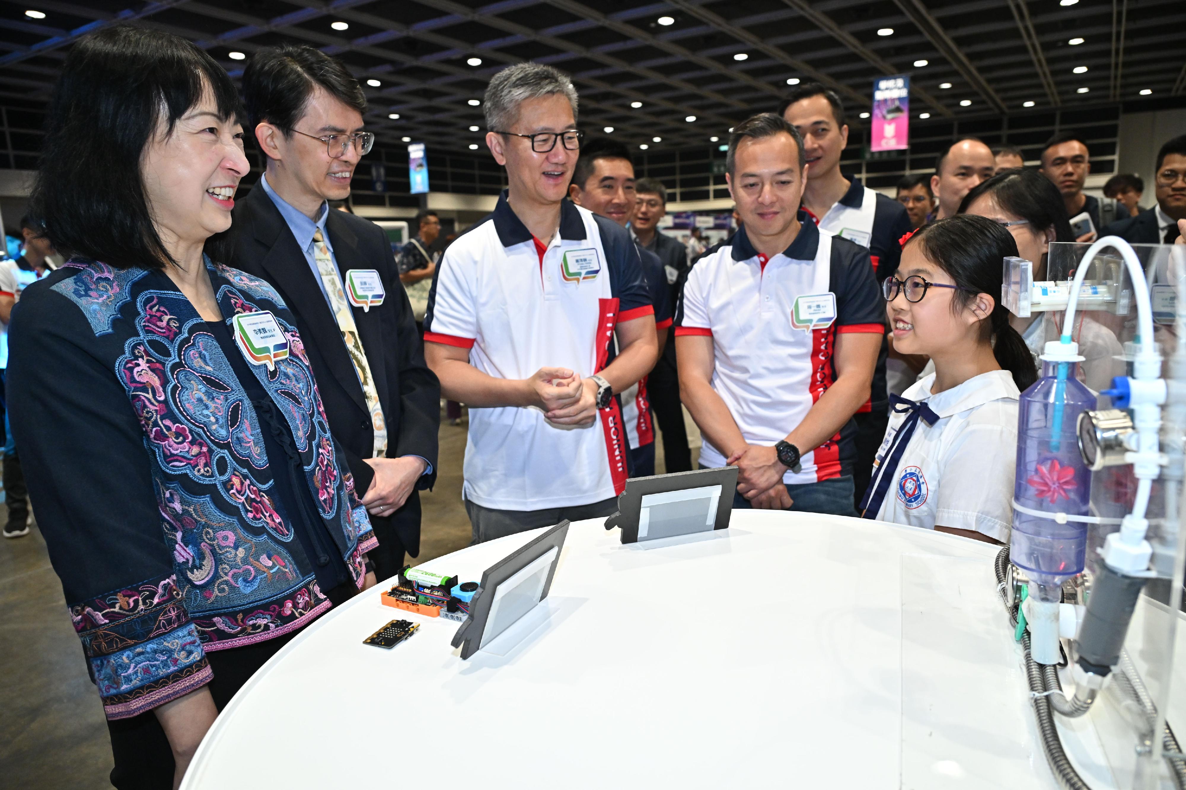 The JPC Innovation and Technology Competition 2023-24, organised by the Junior Police Call, held its award presentation ceremony at the Hong Kong Convention and Exhibition Centre today (May 11). Photo shows the champion of the senior primary category introducing her winning entry to the Commissioner of Police, Mr Siu Chak-yee (third left); the General Manager of Information Technology Department of Bank of China (Hong Kong), Mr Yung Fai (second left); the Permanent Secretary for Education, Ms Michelle Li (first left); and the Deputy Commissioner of Police (Operations), Mr Chow Yat-ming (second right).