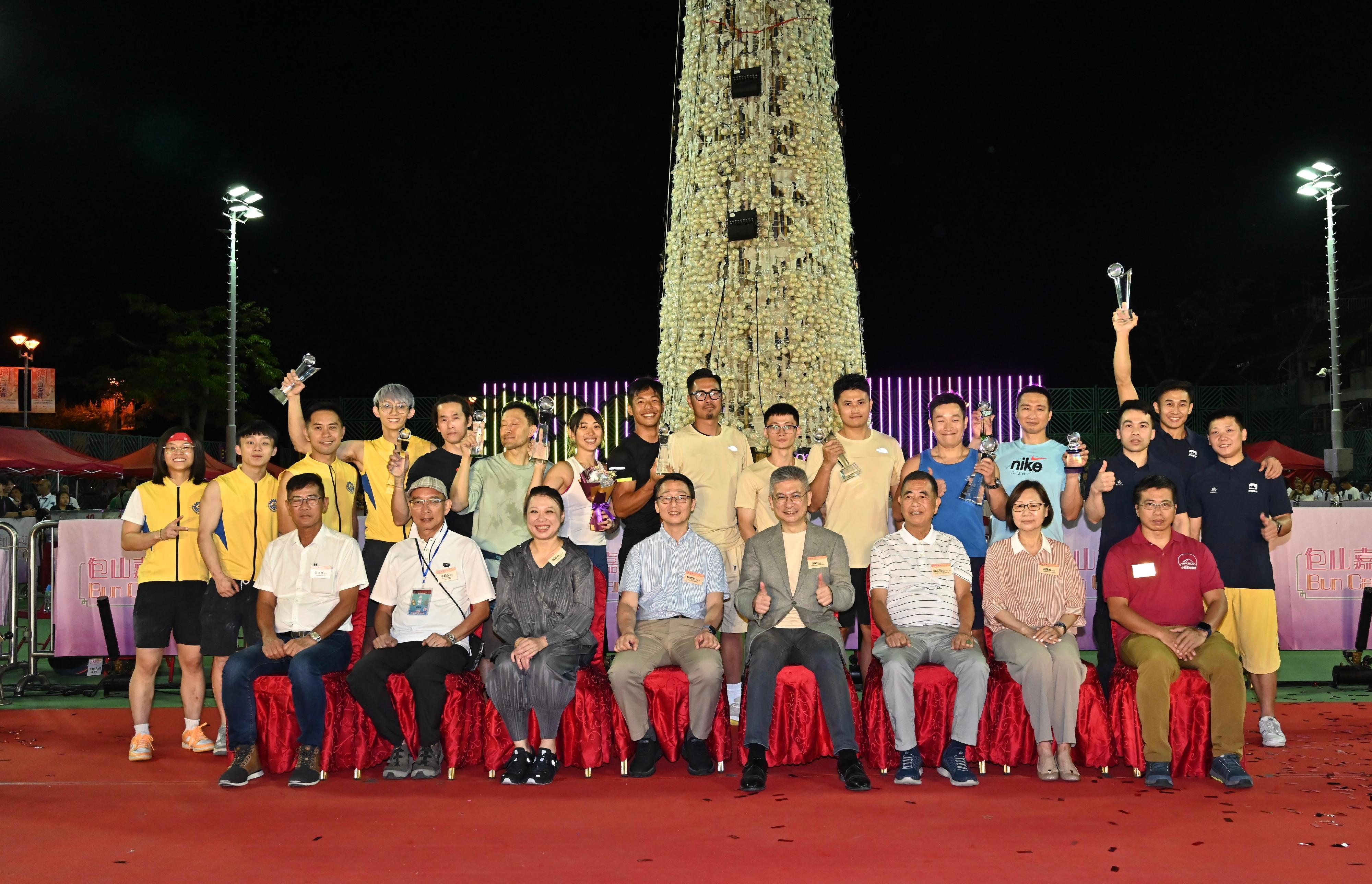 The Bun Scrambling Final in Cheung Chau concluded early this morning (May 16). The Acting Secretary for Culture, Sports and Tourism, Mr Raistlin Lau (front row, fourth right); the Director of Leisure and Cultural Services, Mr Vincent Liu (front row, fourth left); the Chairman of the Hong Kong Cheung Chau Bun Festival Committee, Mr Yung Chi-ming (front row, third right); the Chairman of the Islands District Council, Miss Amy Yeung (front row, third left); and other officiating guests are pictured with the winners.
