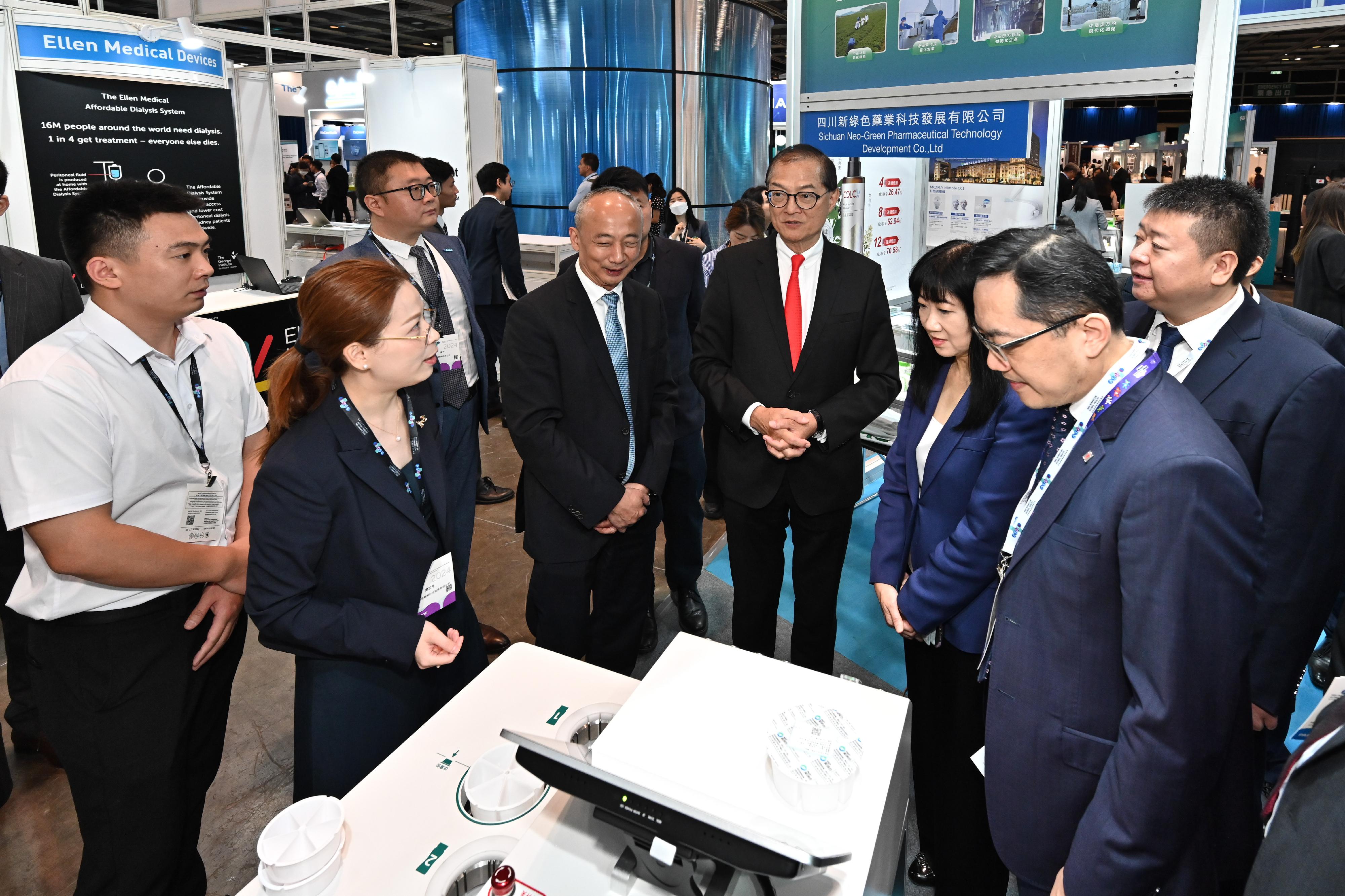 The Secretary for Health, Professor Lo Chung-mau (fourth right), accompanied by the Director of the Sichuan Provincial Administration of Traditional Chinese Medicine, Mr Tian Xingjun (fifth right), tours the booth set up by the Sichuan Provincial Administration of Traditional Chinese Medicine at the Asia Summit on Global Health today (May 16).