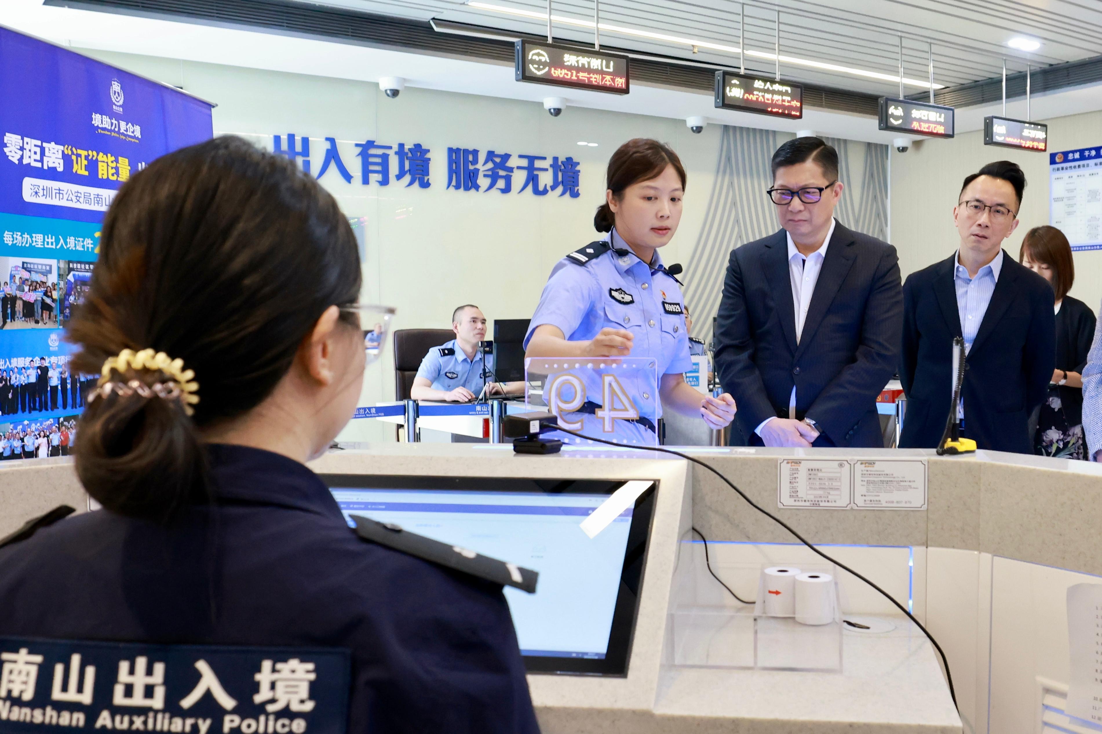 保安局局长邓炳强今日（五月十六日）访问广州和深圳。图示邓炳强（右二）和保安局常任秘书长李百全（右一）今日到访南山公安分局深圳湾服务中心，了解该中心透过提供一站式服务便利市民。