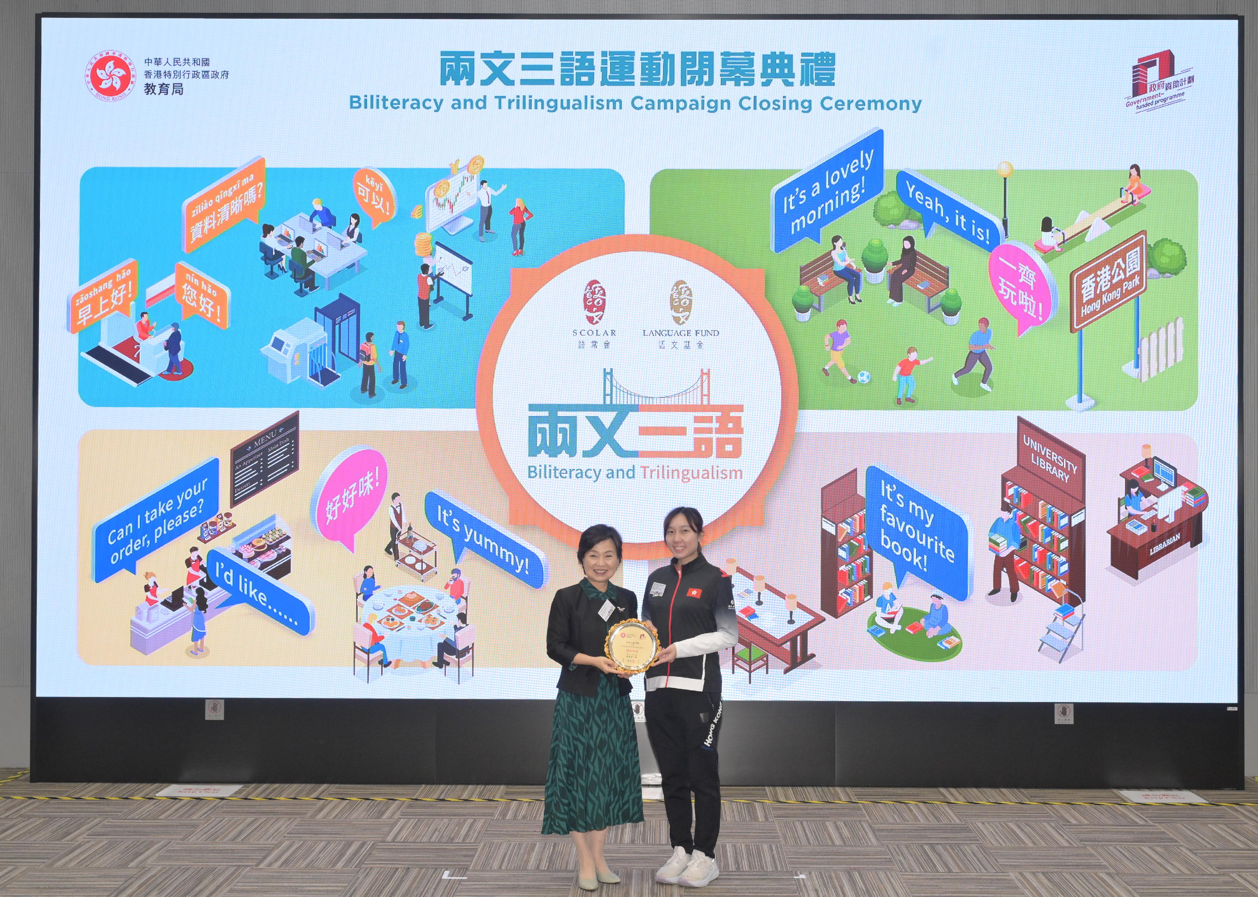 教育局局長蔡若蓮博士（左）頒發紀念品予「兩文三語運動」大使、乒乓球運動員蘇慧音（右）。