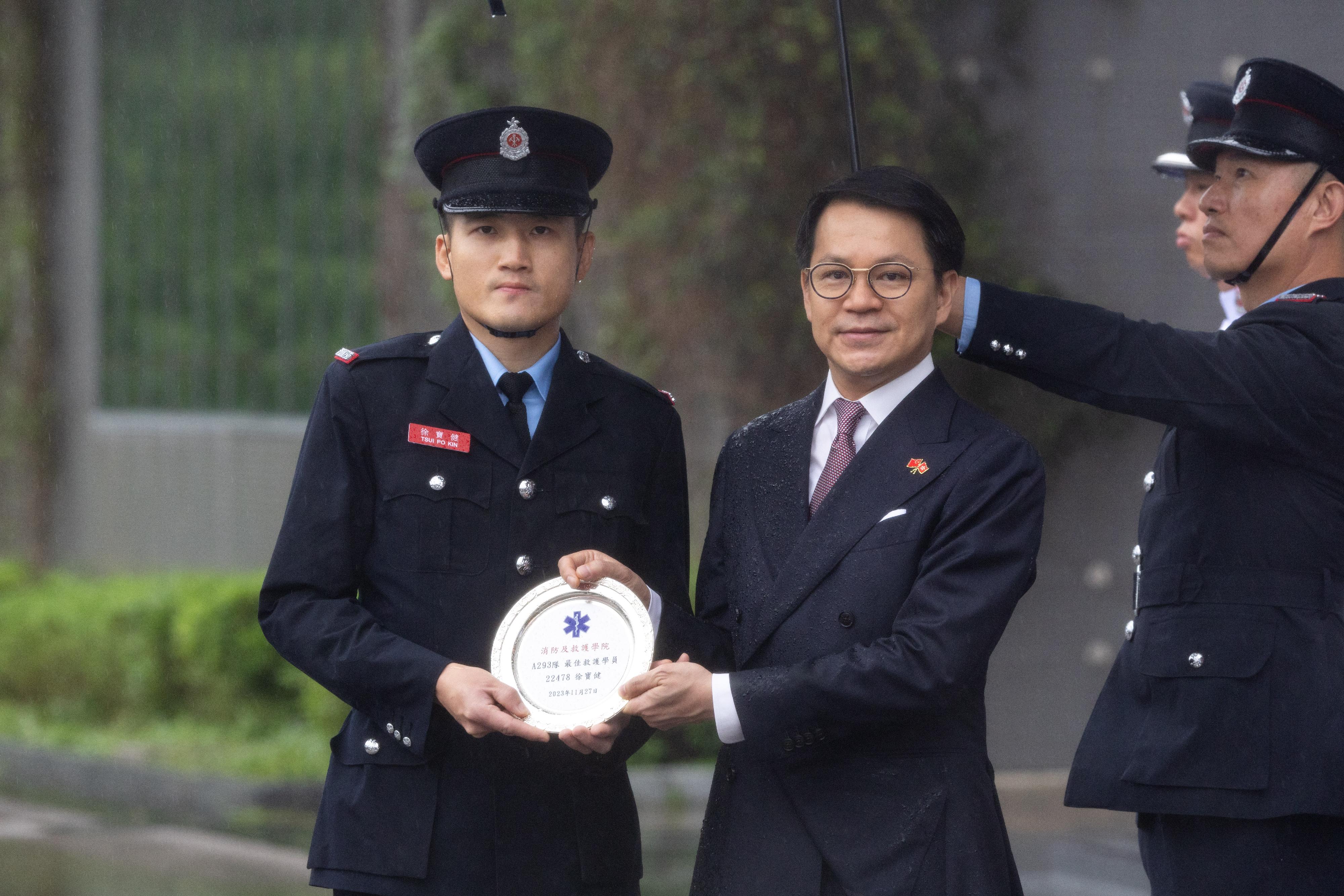 The Chairman of the Legislative Council Panel on Security, Mr Chan Hak-kan, reviewed the Fire Services passing-out parade at the Fire and Ambulance Services Academy today (May 24). Photo shows Mr Chan (second left) presenting the Best Recruit Ambulanceman award to a graduate.