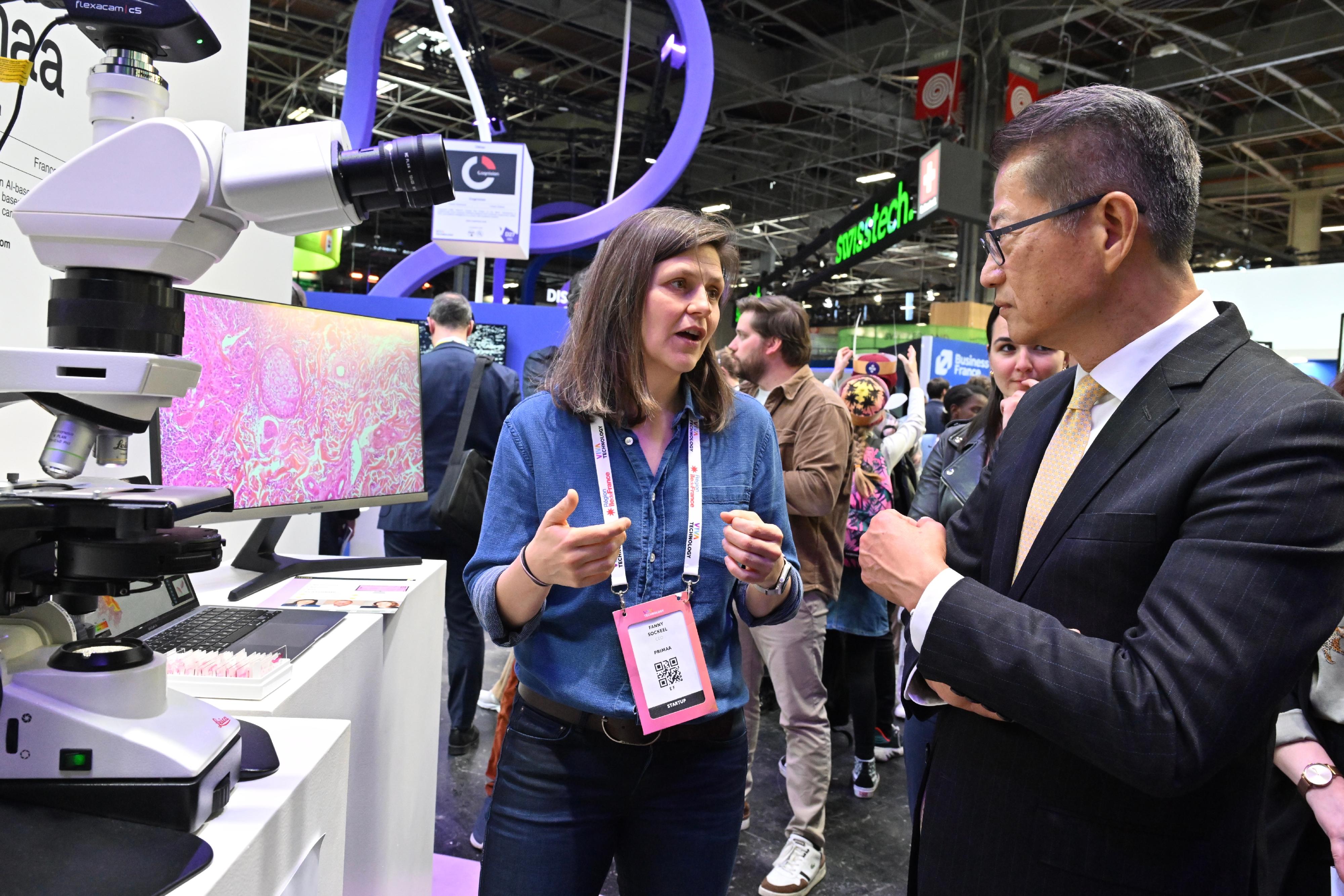 The Financial Secretary, Mr Paul Chan, visited VivaTech 2024, Europe's largest annual technology and startup event, yesterday (May 24, Paris Time). Photo shows Mr Chan (right) visiting an enterprise participating in the event.