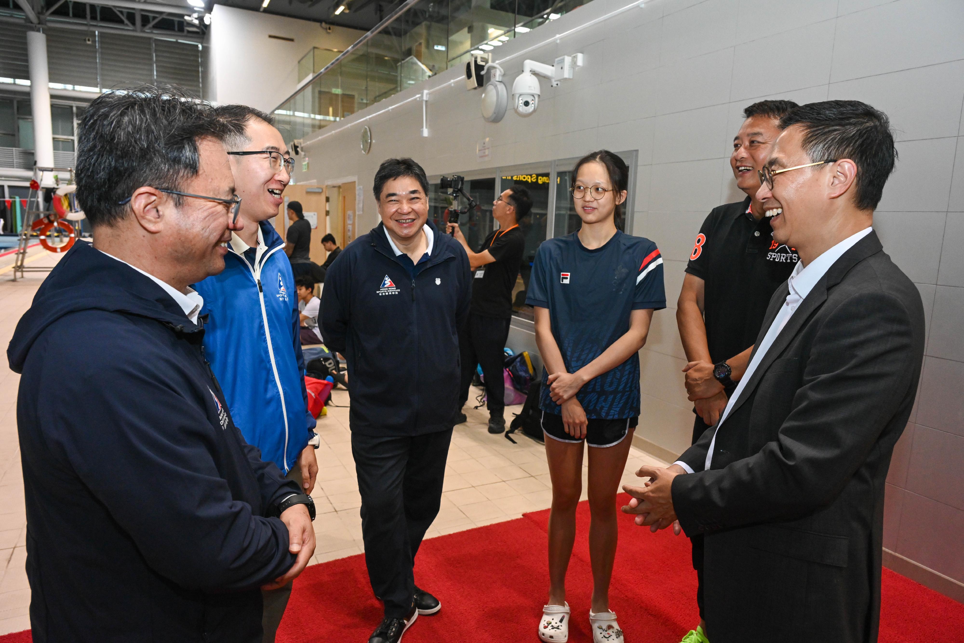 文化体育及旅游局局长杨润雄（右一）今日（五月二十七日）下午和体育专员黄德森，到访香港体育学院，在游泳馆与备战的运动员会面交流。
