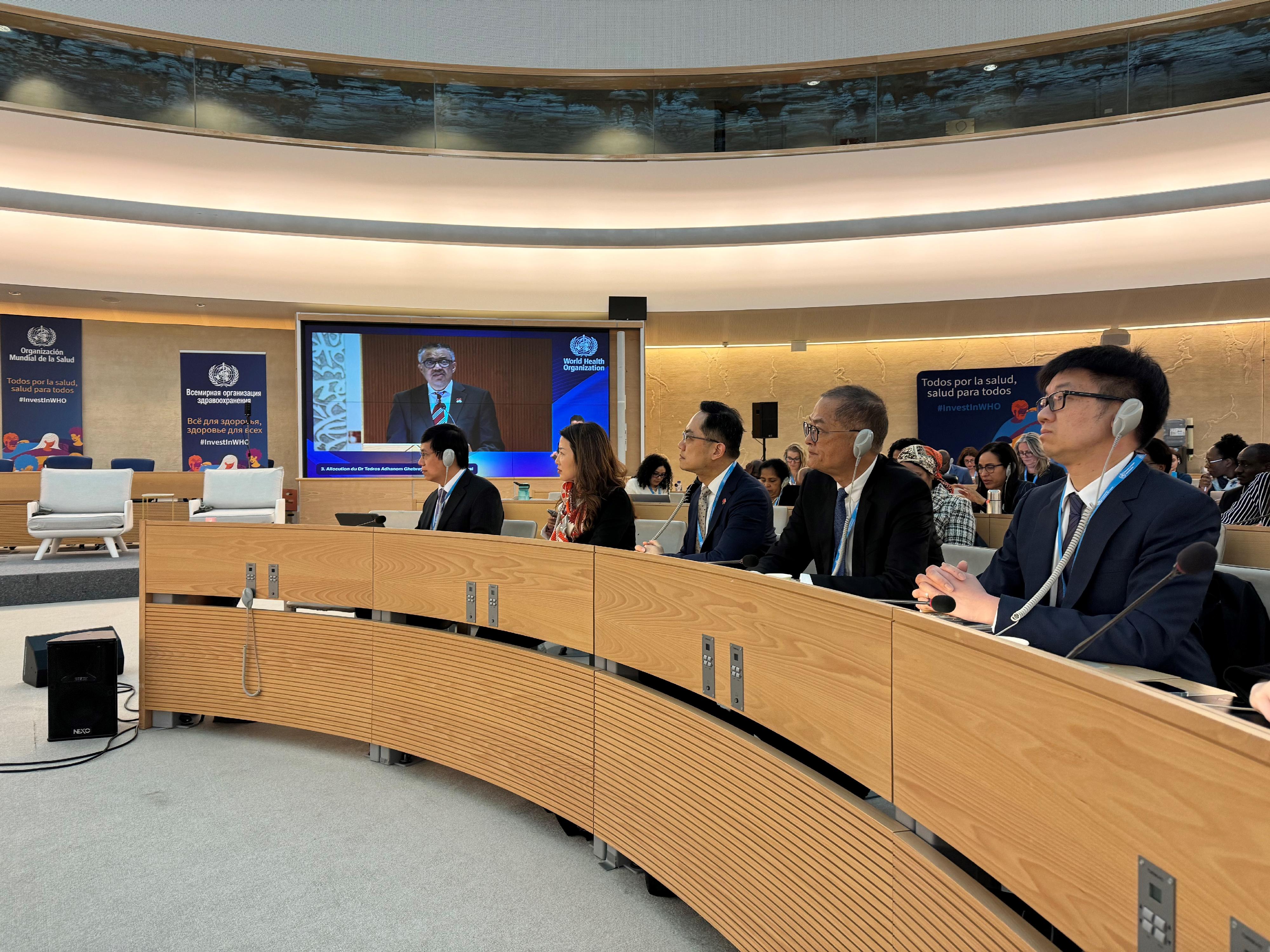 The Secretary for Health, Professor Lo Chung-mau (second right), and the Director of Health, Dr Ronald Lam (third right), attended the 77th World Health Assembly of the World Health Organization (WHO) in Geneva, Switzerland, as members of the Chinese delegation on May 27 (Geneva time). Photo shows them listening to the remarks made by the Director-General of the WHO, Dr Tedros Adhanom Ghebreyesus (on the screen), during the Assembly.