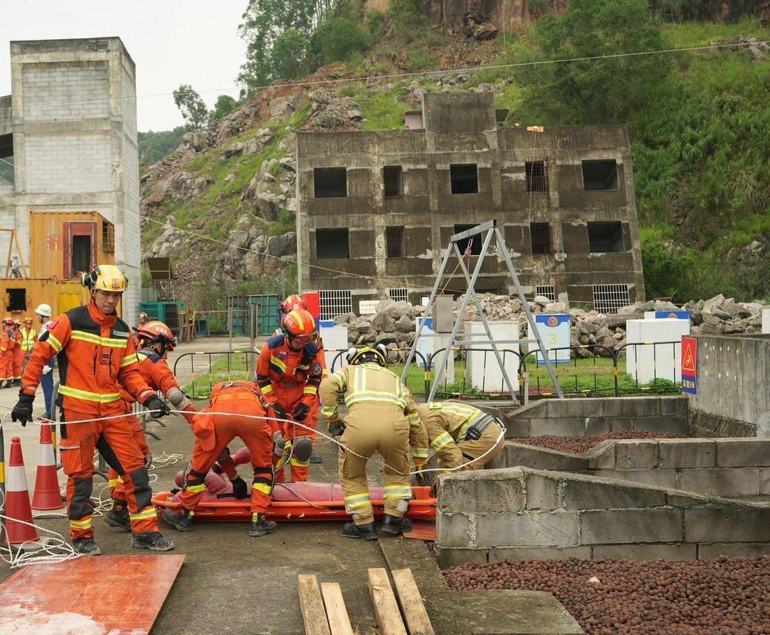 The Fire and Rescue Corps of Guangdong Province, the Hong Kong Fire Services Department and the Macao Fire Services Bureau have conducted the Guangdong-Hong Kong-Macao Greater Bay Area joint emergency response and rescue exercise "Liancheng-2024" in Jiangmen, Guangdong Province from May 27 to today (May 29). Photo shows personnel from the three places working together to rescue a person buried in debris flow and transport the trapped person to the surface.