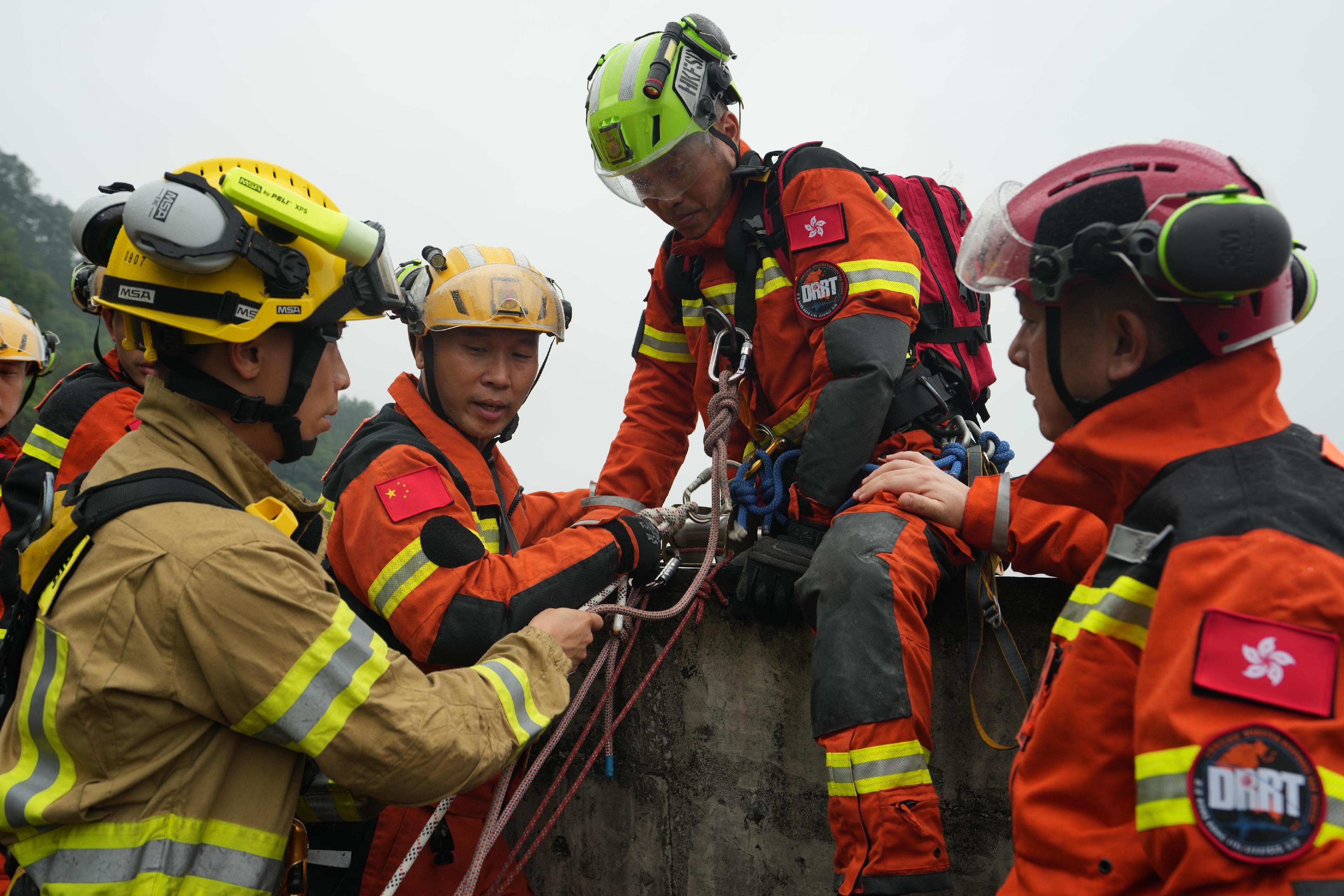 The Fire and Rescue Corps of Guangdong Province, the Hong Kong Fire Services Department and the Macao Fire Services Bureau have conducted the Guangdong-Hong Kong-Macao Greater Bay Area joint emergency response and rescue exercise "Liancheng-2024" in Jiangmen, Guangdong Province from May 27 to today (May 29). Photo shows rescue teams from Hong Kong and Macao working together to set up a rope system for rescue operations.