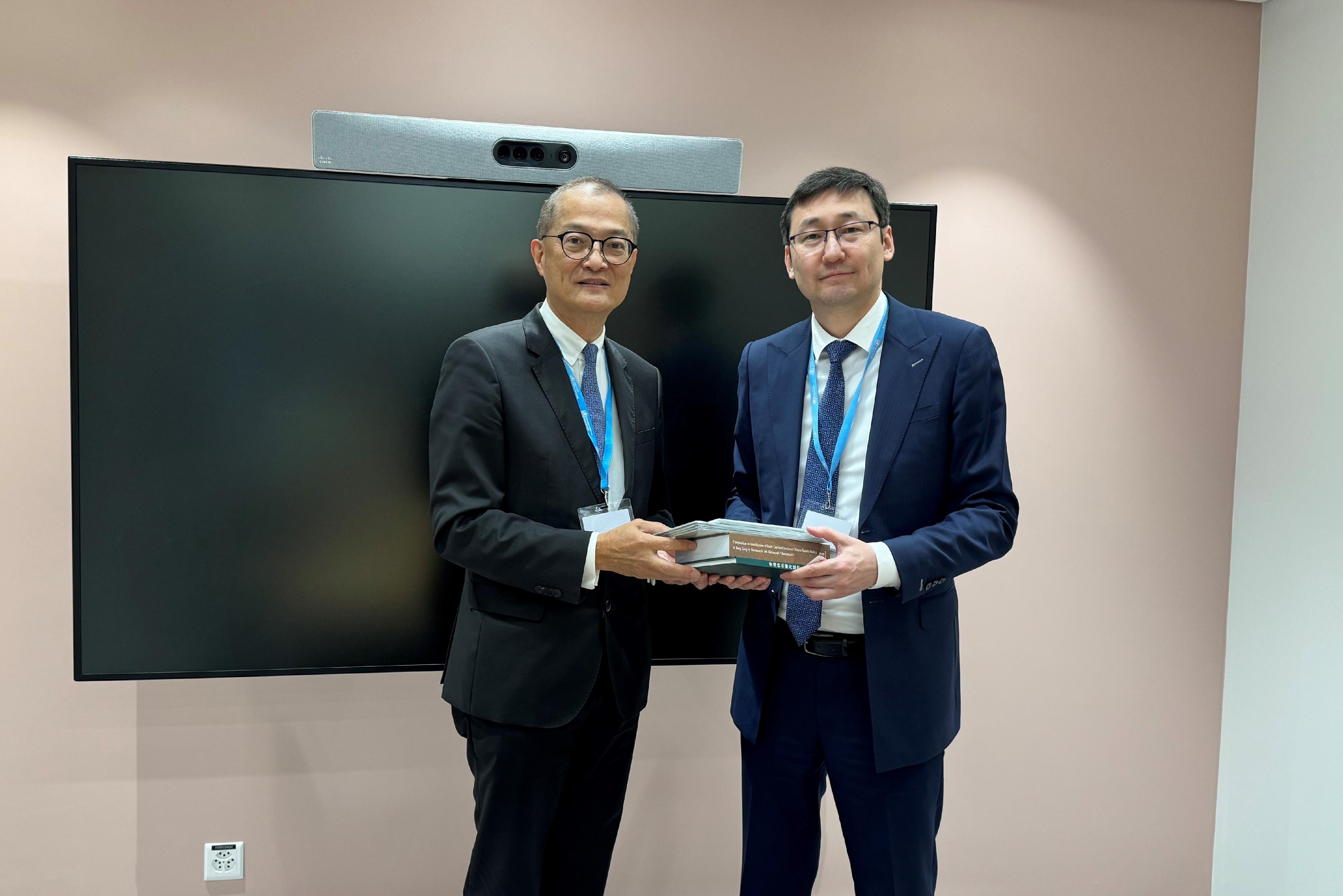 The Secretary for Health, Professor Lo Chung-mau (left), presents two books published by the Department of Health under the titles of “Hong Kong Characteristic Medicinal Plants” and “Compendium on Identification of Easily Confused Species of Chinese Materia Medica in Hong Kong by Macroscopic and Microscopic Characteristics” to the First Deputy Minister of Healthcare of the Republic of Kazakhstan, Mr Timur Sultangaziyev (right), in Geneva, Switzerland, on May 28 (Geneva time).