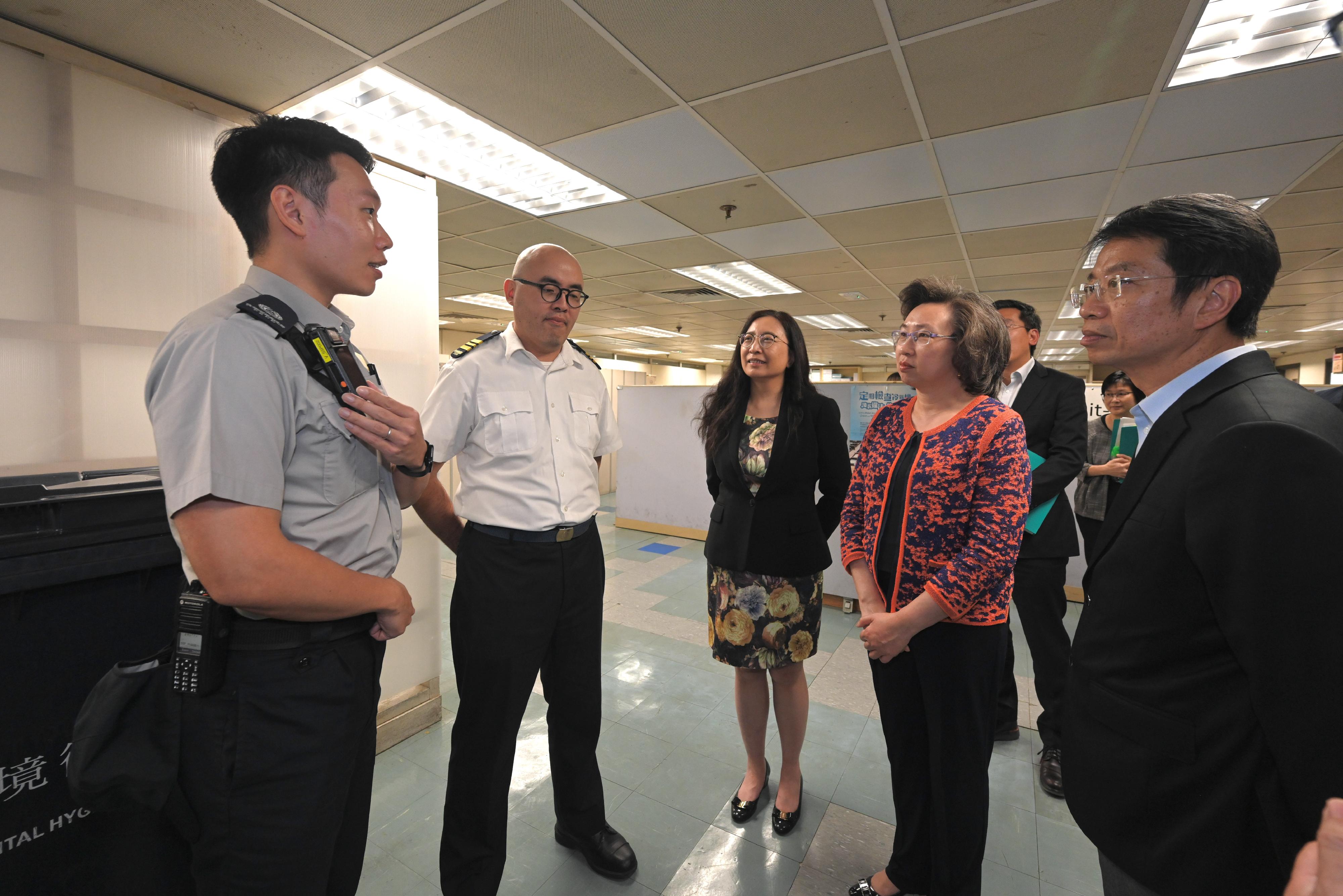 The Secretary for the Civil Service, Mrs Ingrid Yeung, visited the Food and Environmental Hygiene Department today (May 29) to learn more about the department's work. Photo shows Mrs Yeung (second right) visiting the Sham Shui Po Hawker Control Team and was briefed by a team member on the enforcement situation in regulating hawking activities and combating illegal extension of business area by shops, as well as how the body-worn video camera equipped to the Hawker Control Team can record the on-site situation when necessary in the course of discharging their duties more effectively and safeguarding the safety of the public and staff. Looking on are the the Permanent Secretary for the Civil Service, Mr Clement Leung (first right), and the Director of Food and Environmental Hygiene, Ms Irene Young (centre).