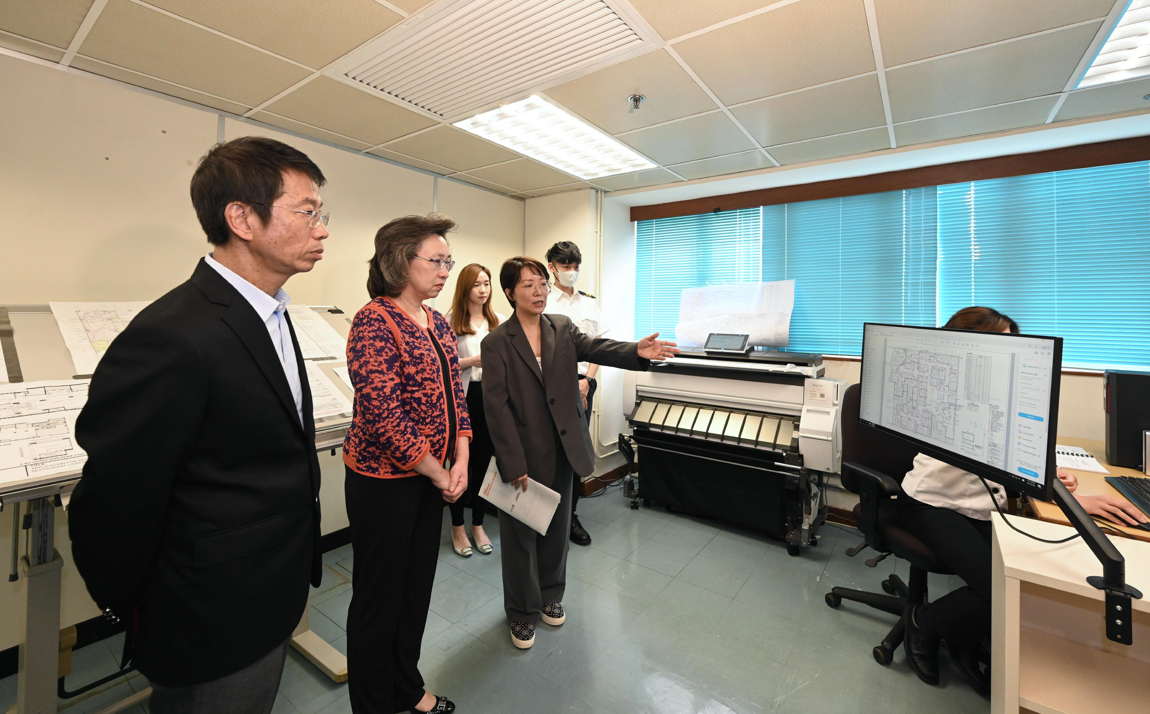 The Secretary for the Civil Service, Mrs Ingrid Yeung, visited the Food and Environmental Hygiene Department today (May 29) to learn more about the department's work. Photo shows Mrs Yeung (second left) visiting the Licensing Section of Kowloon and being introduced by a staff on the use of information and technology to streamline the workflow to reduce the manual process of calculating the area of food premises, with a view to enhancing work efficiency. Looking on is the Permanent Secretary for the Civil Service, Mr Clement Leung (first left).