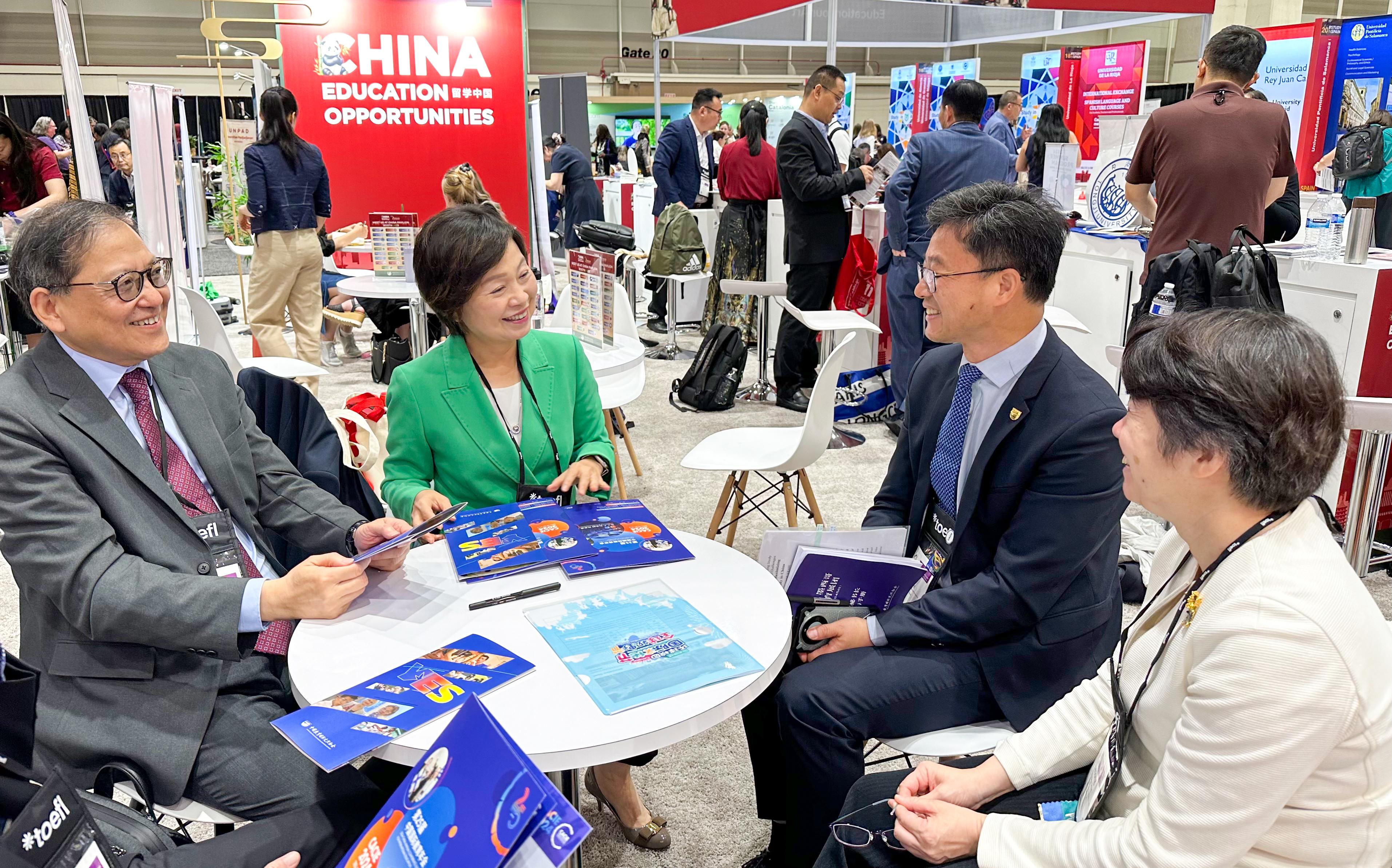 The Secretary for Education, Dr Choi Yuk-lin, visited booths of various countries and regions at the NAFSA Annual Conference & Expo in New Orleans, the United States, on May 29 (New Orleans time). Photo shows Dr Choi (second left) and the Secretary-General of the University Grants Committee, Professor James Tang (first left), chatting with representatives of the China Education Association for International Exchange.