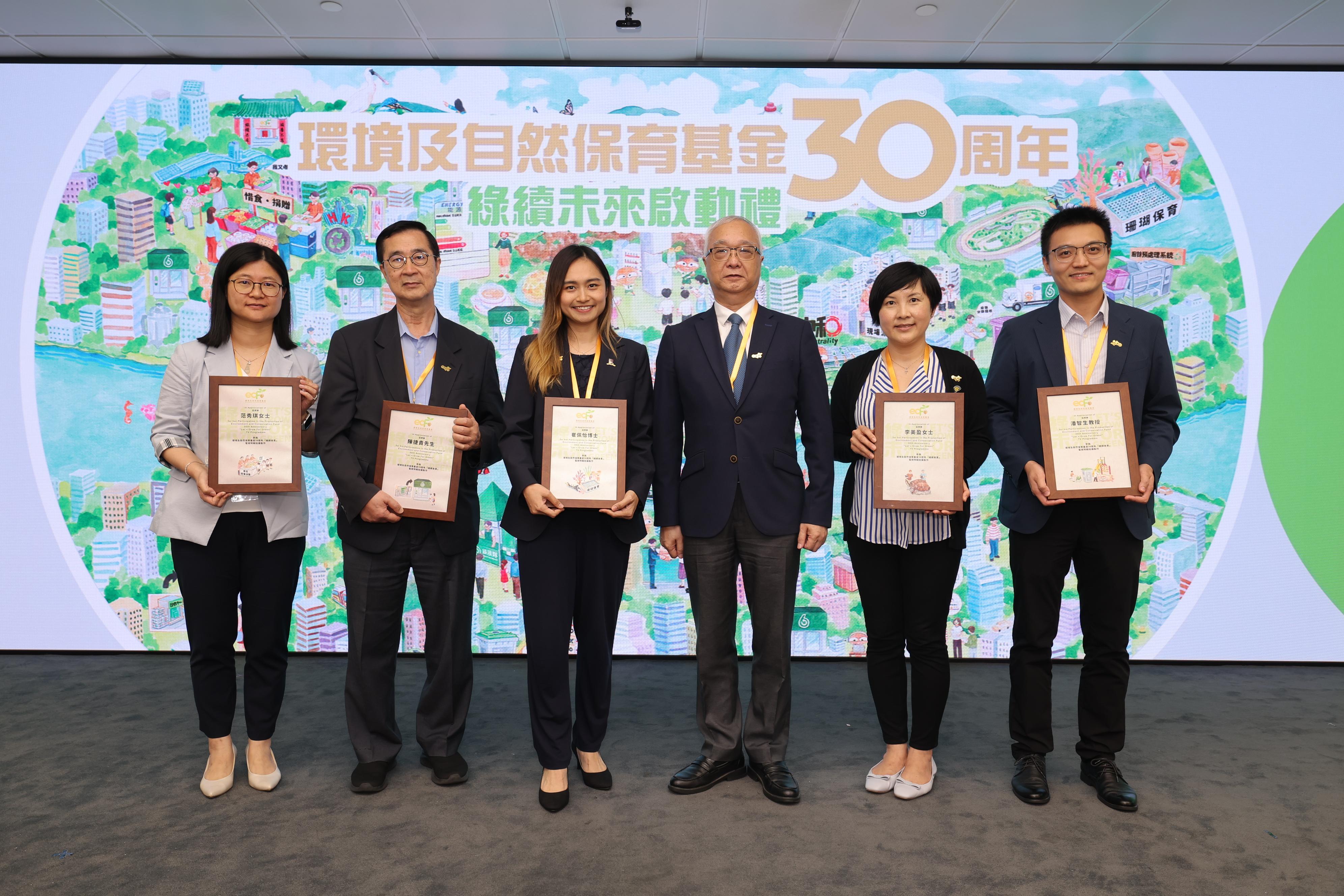 The Environment and Conservation Fund (ECF) 30th anniversary "Let's Grow for Green" launching ceremony was held at the Hong Kong Productivity Council Building in Kowloon today (June 3). Photo shows the Secretary for Environment and Ecology, Mr Tse Chin-wan (third right), presenting appreciation certificates to the guests participating in the ECF 30th anniversary television programme at the launching ceremony.