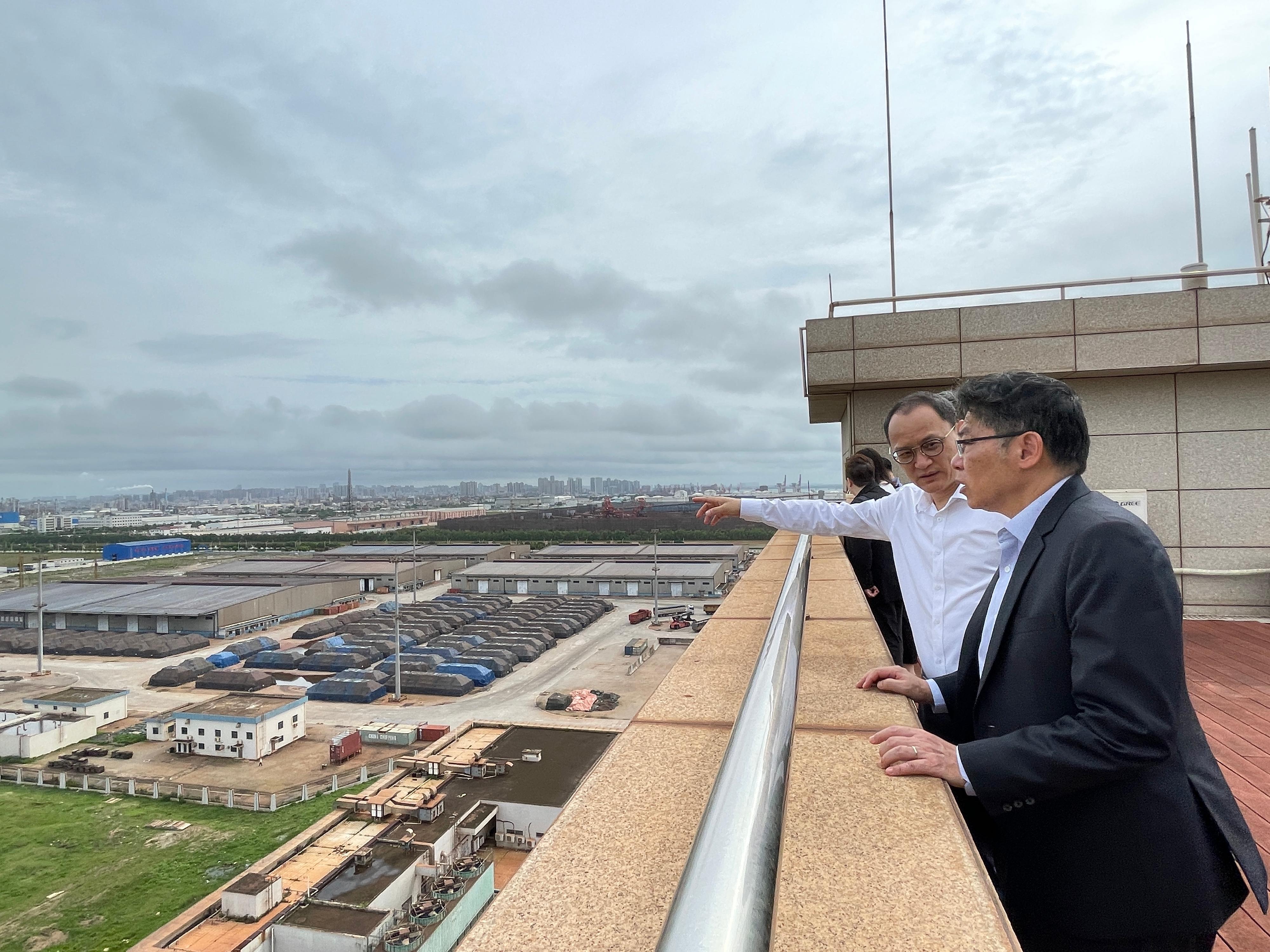 The Secretary for Transport and Logistics, Mr Lam Sai-hung (right), is briefed on the development of Zhanjiang's industries during his visit to the city today (June 5).