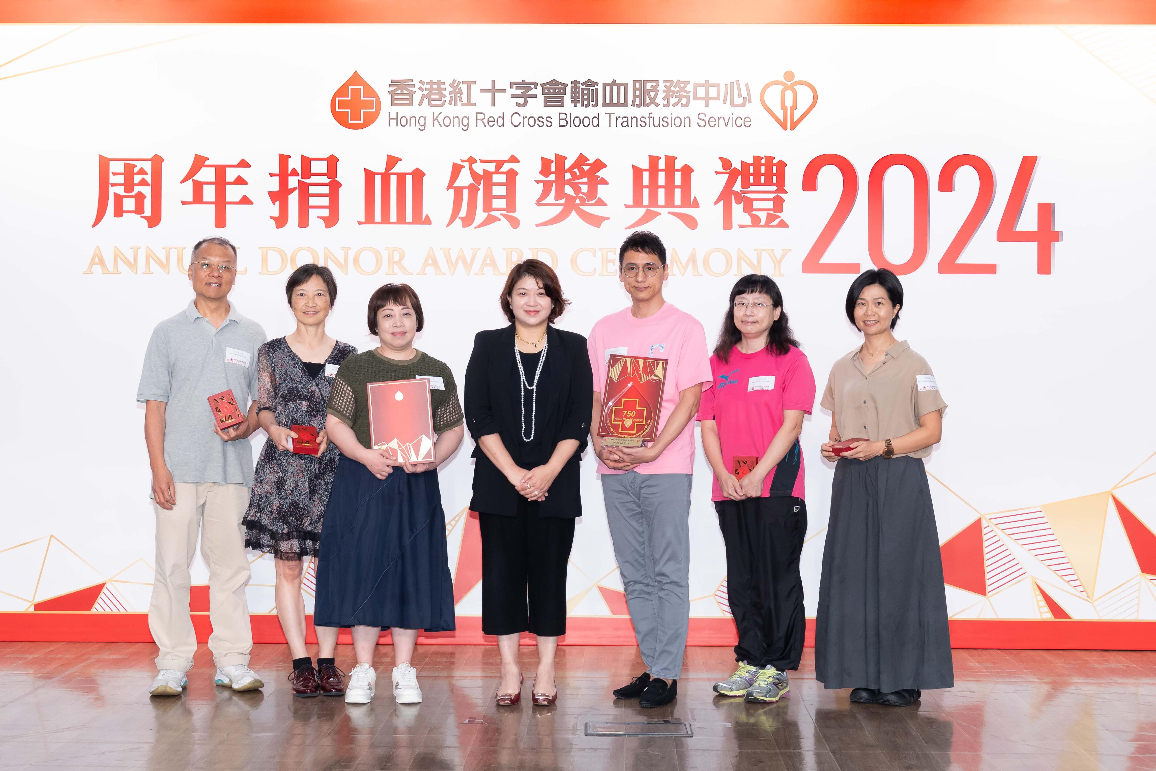 香港红十字会输血服务中心今日（六月八日）举行周年捐血颁奖典礼，嘉许一班长期支持捐血的恒常捐血者。图示医务卫生局副局长李夏茵医生（中）颁发奖项予一众获嘉许的捐血者。