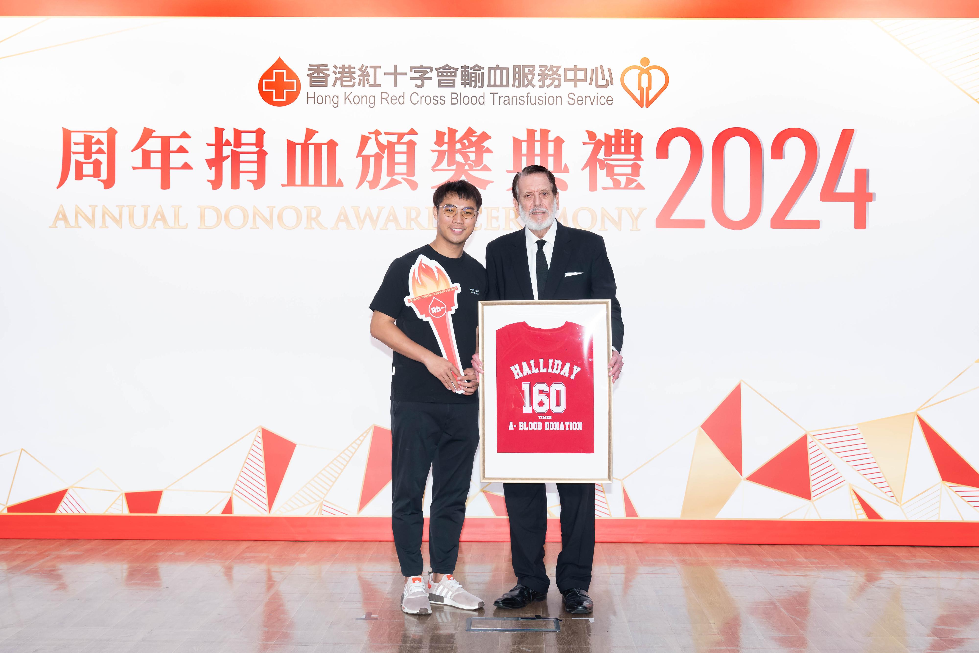 The Hong Kong Red Cross Blood Transfusion Service today (June 8) held its Annual Donor Award Ceremony to commend outstanding regular blood donors. Photo shows 76-year-old Peter Ernest Halliday (right), record keeper of male negative blood donor, retiring from blood donation and passing the torch to Wong Chik-kwan (left), one of the young members of the negative blood donor group.