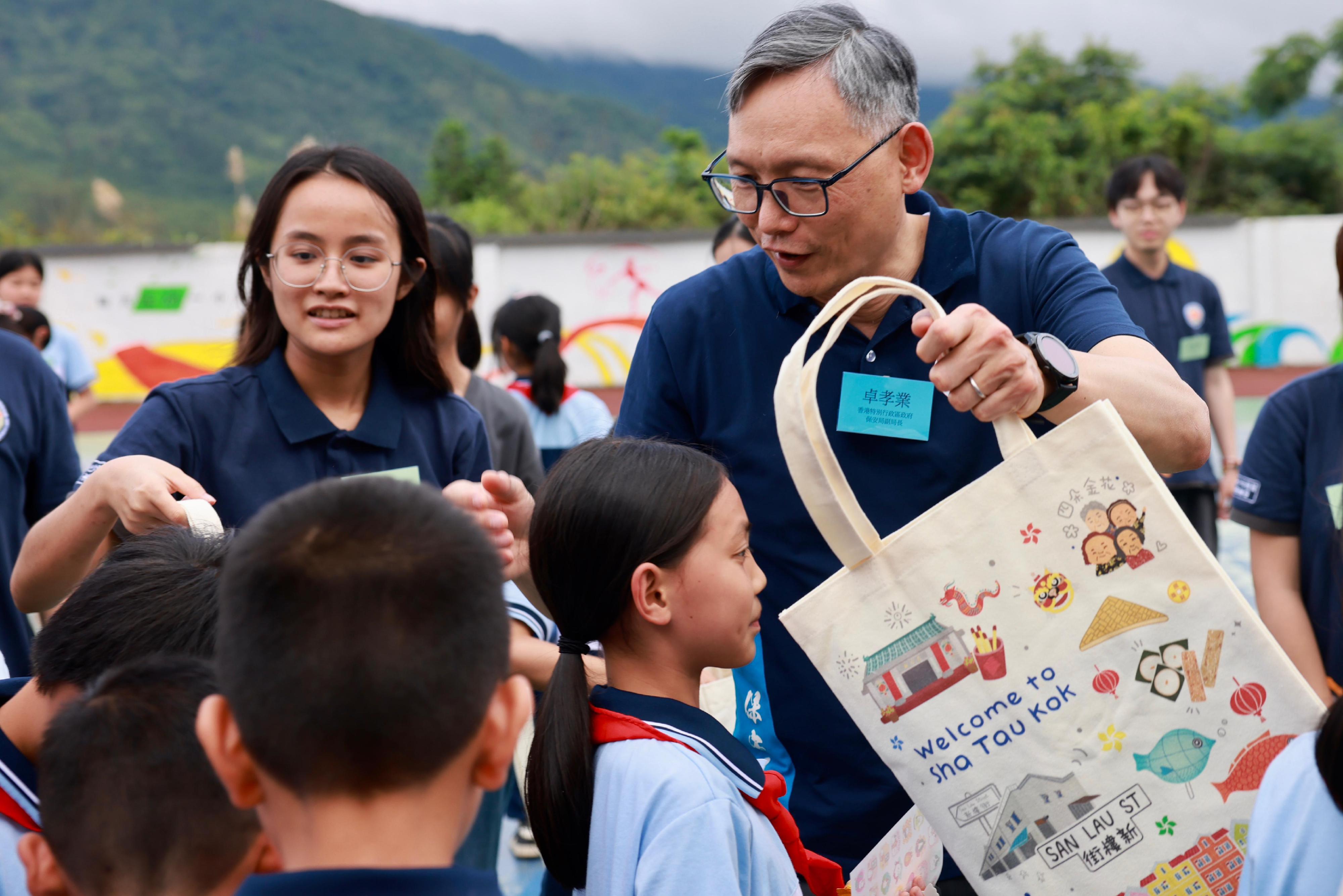 Security Bureau Youth Uniformed Group Leaders Forum (Leaders Forum) concluded a three-day visit to the Greater Bay Area today (June 10). Photo shows the Under Secretary for Security, Mr Michael Cheuk (right), with Leaders Forum members and Shenzhen University students leading primary school students in Liyuan, Heyuan, to participate in activities planned by them on June 8.